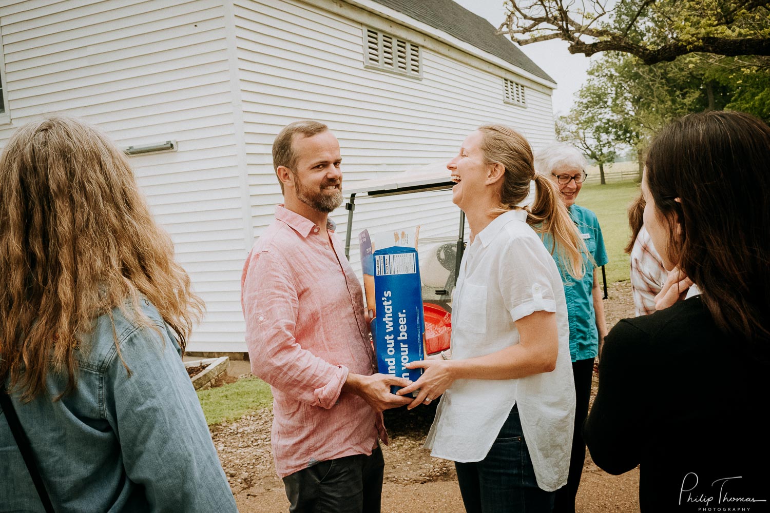 Couple start loading up for the wedding reception and laugh as they hand over beer at The Grand Texana