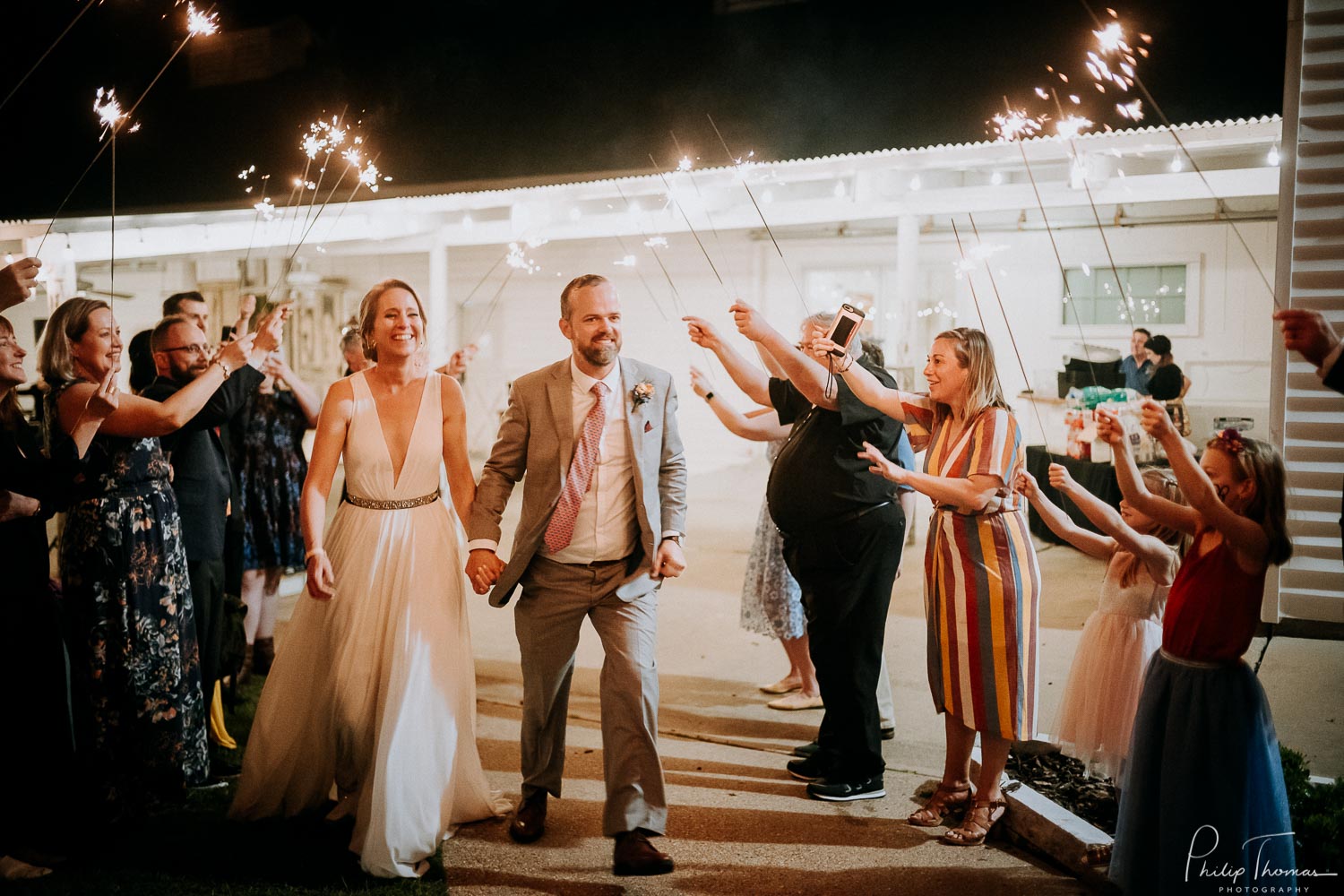 Jubilant expressions on the couple faces at they depart under sparklers The Grand Texana Wedding Barr Minta + Phillip -