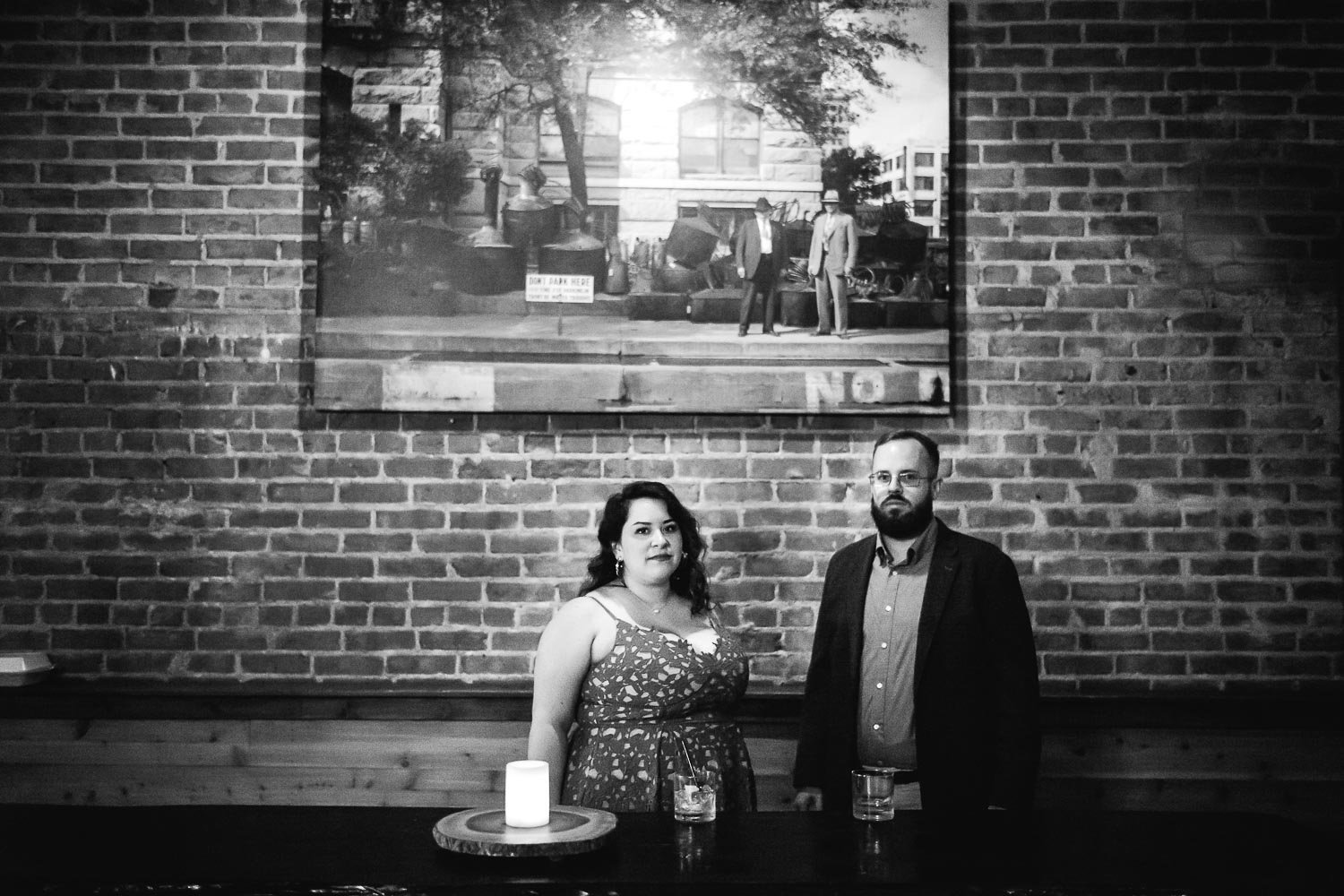 Standing in front of a photograph at Dean’s Downtown Luci and Bryans engagement session downtown Theater District Houston Texas-Philip Thomas Photography