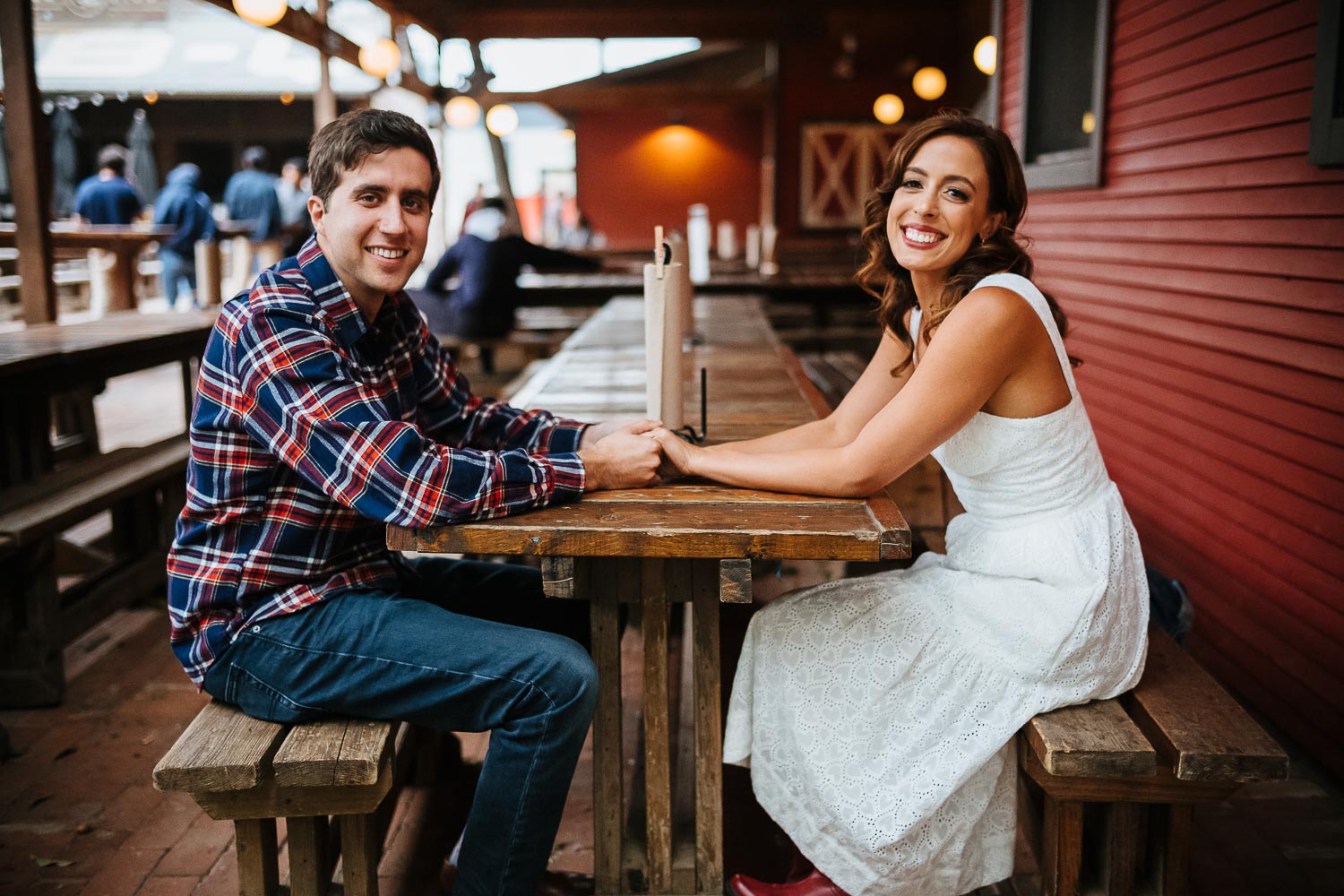 At Banger's in Austin for a rehearsal dinner shows couple holding hands at table