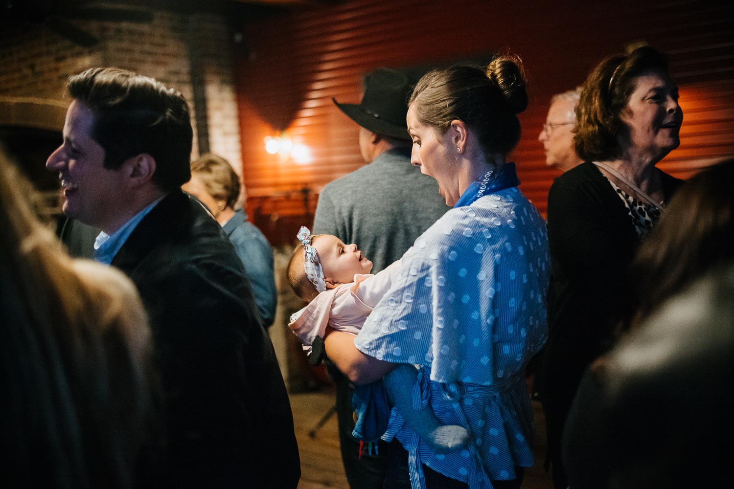 A guest looks down at her daughter during a rehearsal dinner at Banger's in Austin on Rainey Street