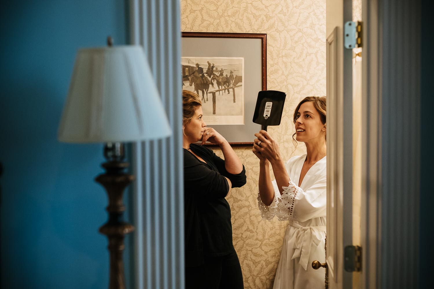 Bride with mirror and friend checking makeup at Driskill Hotel in Austin Texas