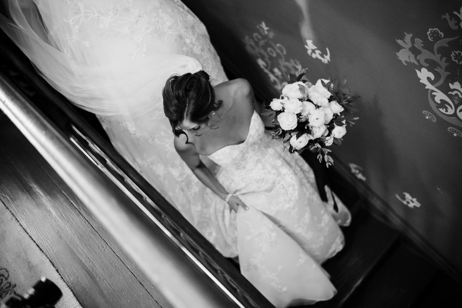 Bride descends sown staircase shot diagonally at Barr Mansion, Texas