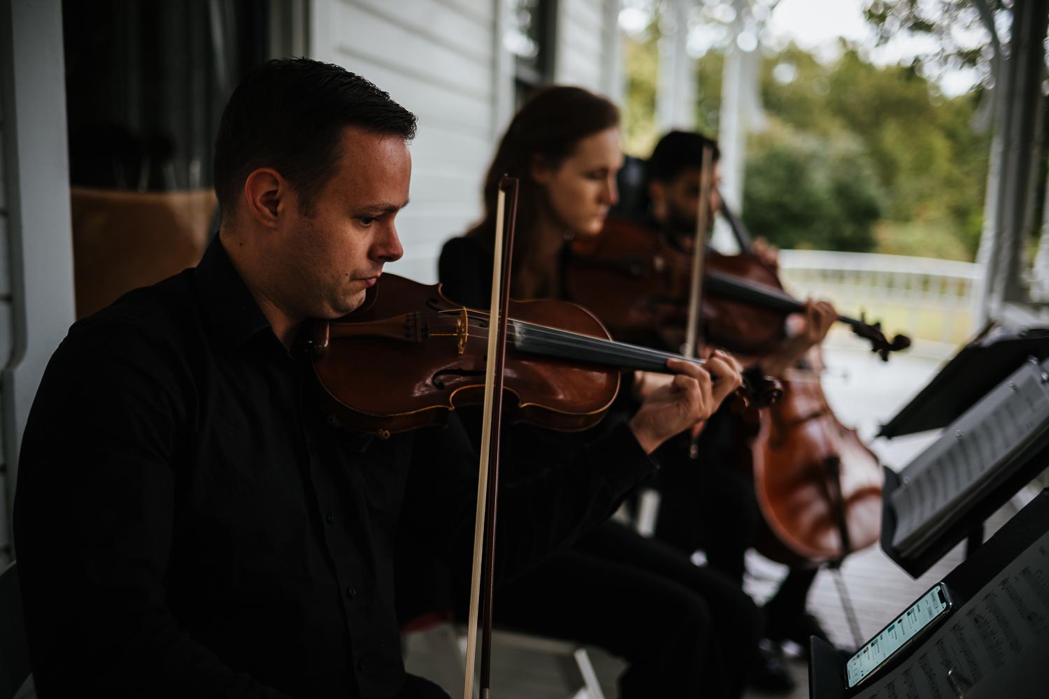 Violinists start playing prelude at a Jewish wedding outdoors at Barr Mansion, Texas