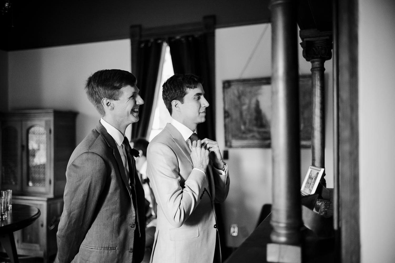 The groom checks in the mirror with a groomsmen nodding in approval Barr Mansion, Texas