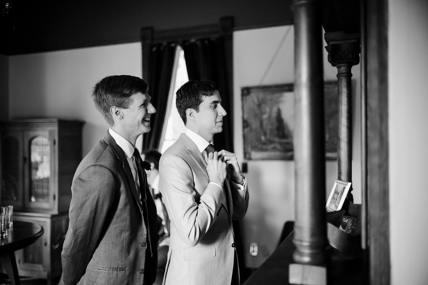 The groom checks in the mirror with a groomsmen nodding in approval Barr Mansion, Texas
