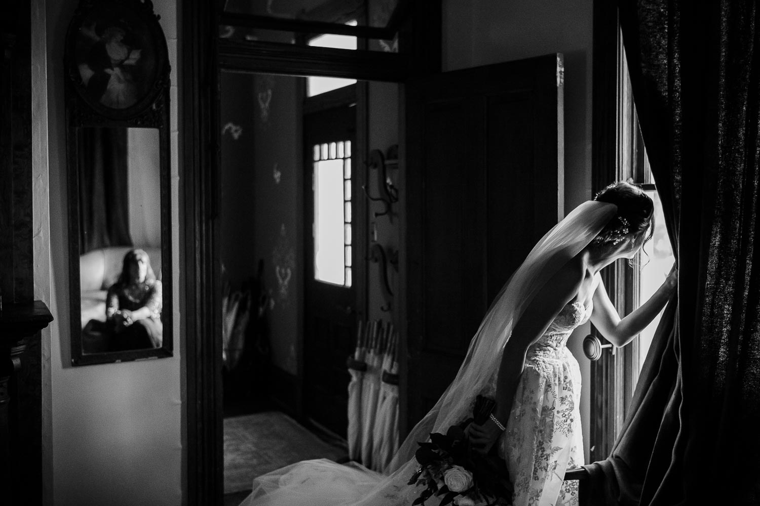 During the procession, a bride peeks out of the window to see the wedding procession at Barr Mansion, Texas