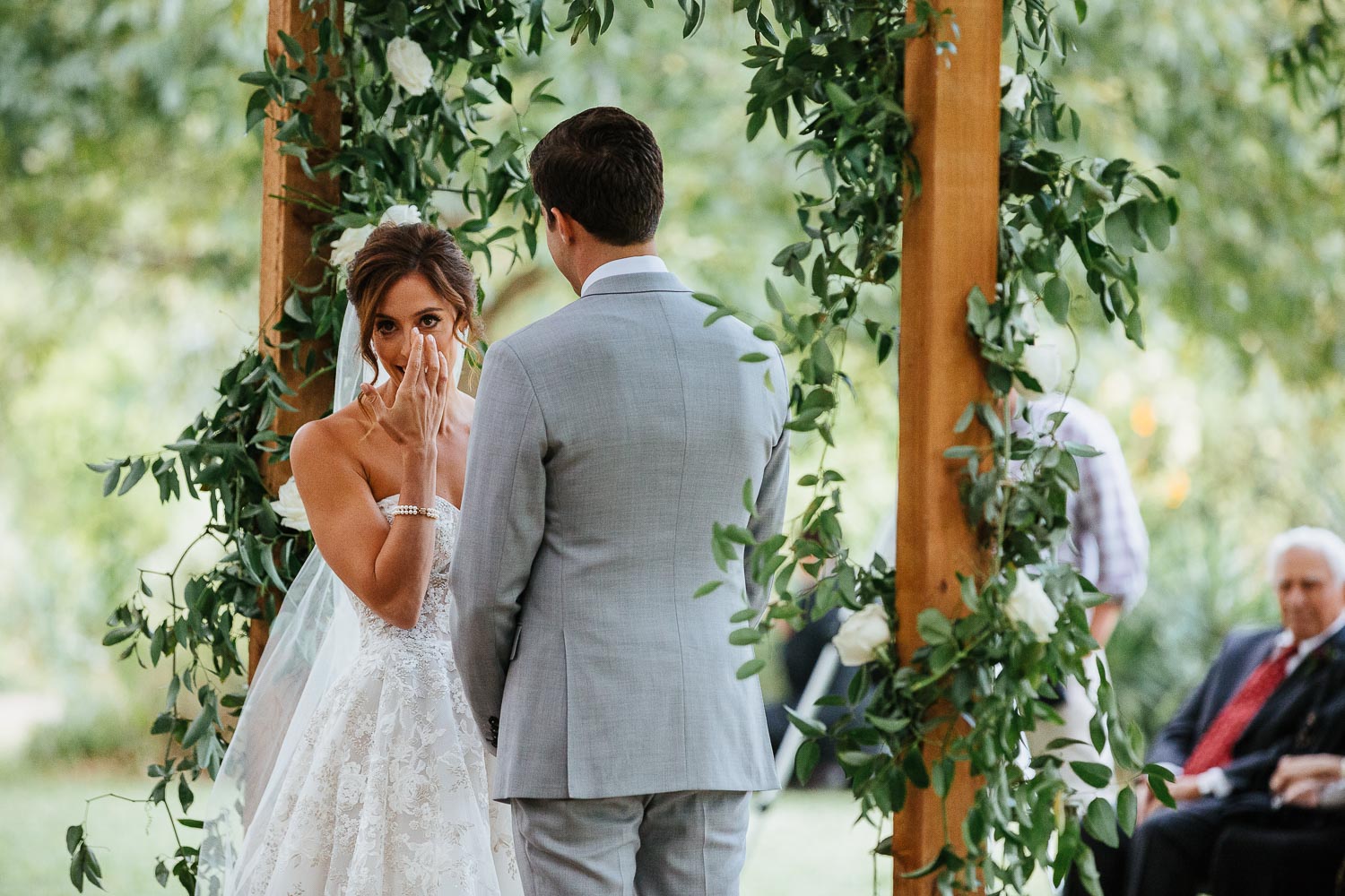 The bride wipes away a tear during a wedding ceremony at Barr Mansion, Texas