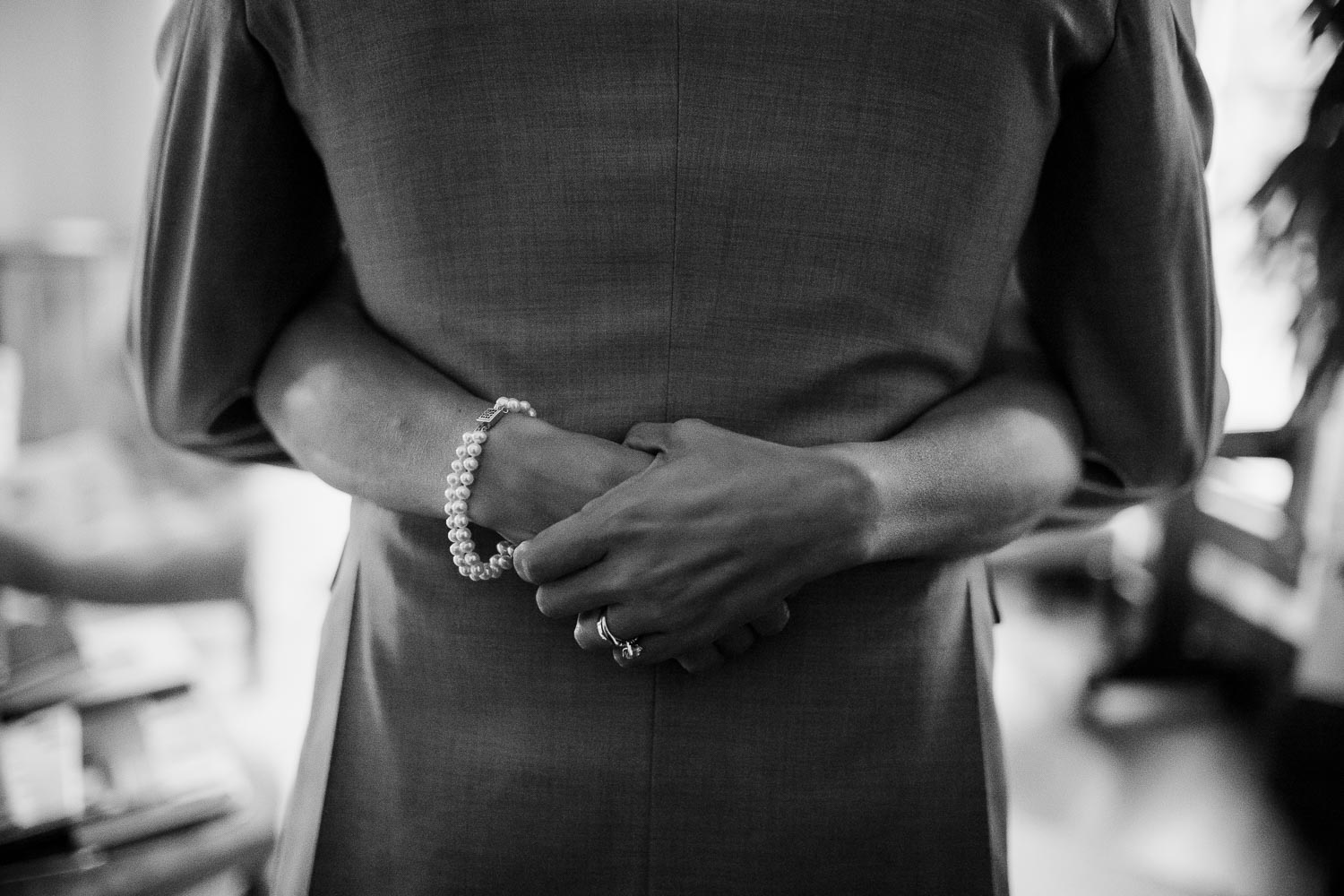 Brides hands wrapped round grooms waist