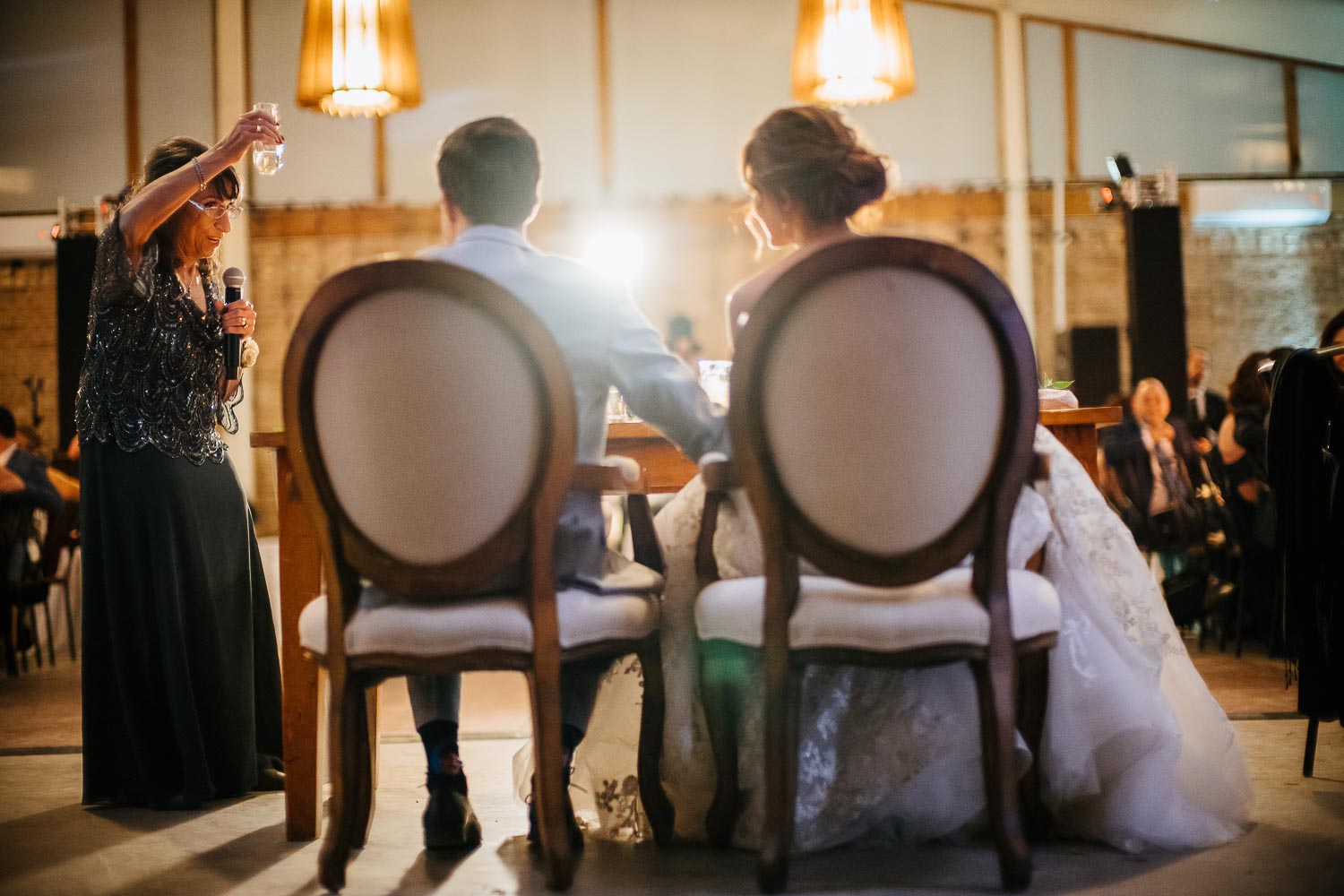 Photographed from behind couples chair during dinner and speeches