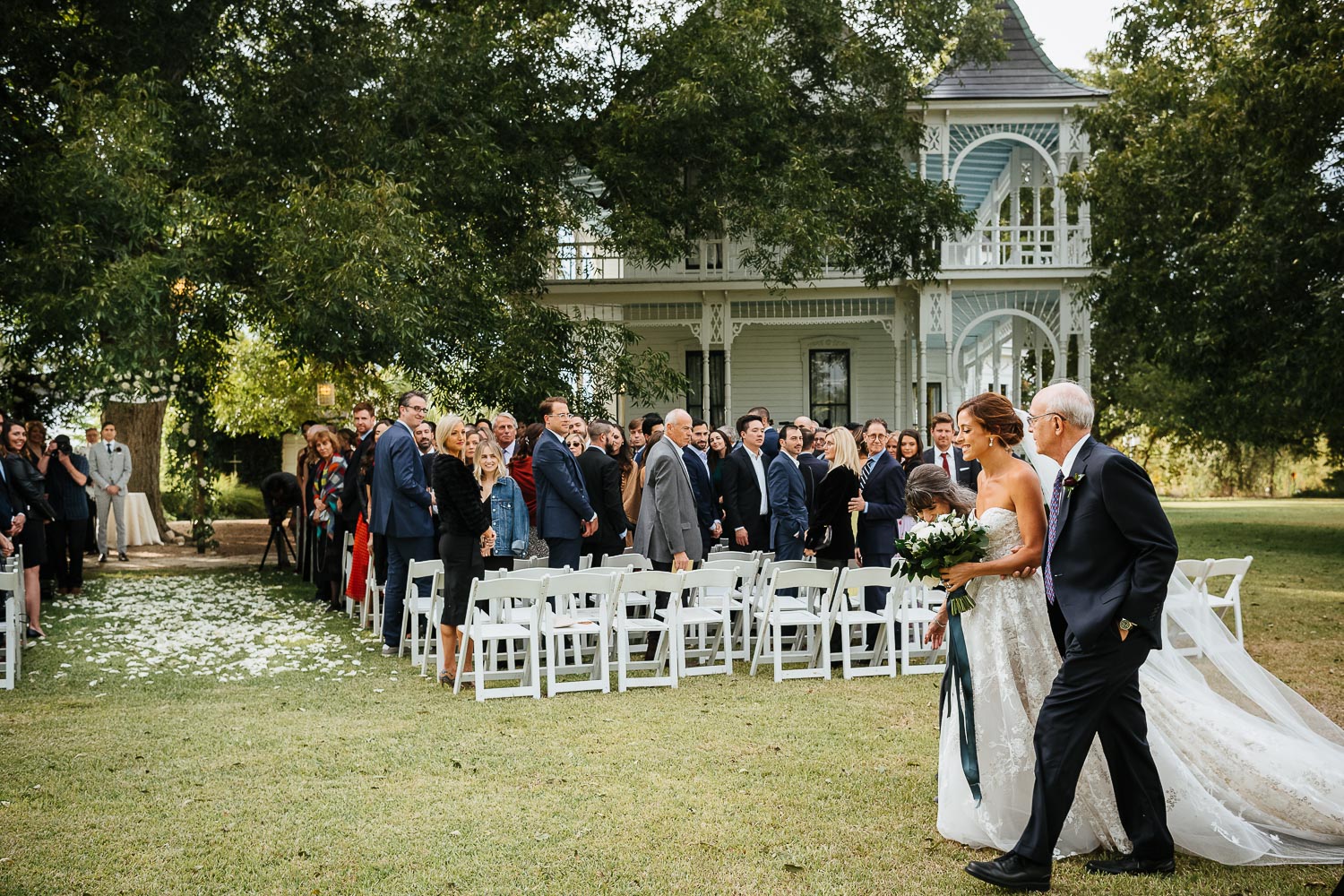 The bride and father during the wedding procession at Barr Mansion, Texas as the groom waits under the chupah Barr Mansion, Texas