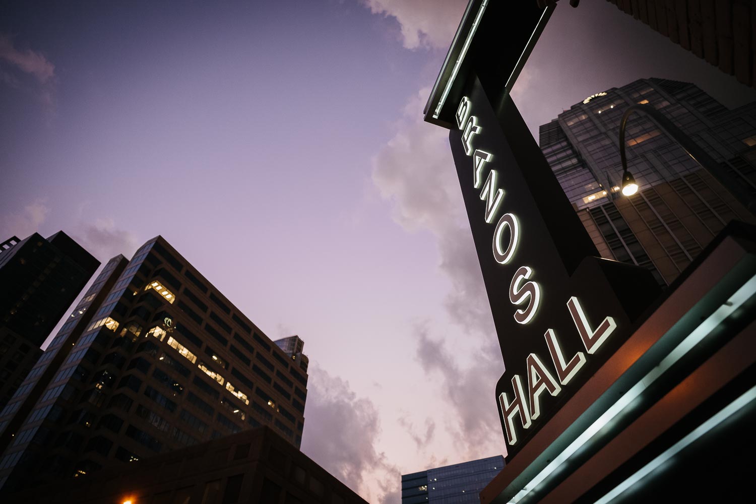 Brazos Hall signage outside at dusk in fall of 2019