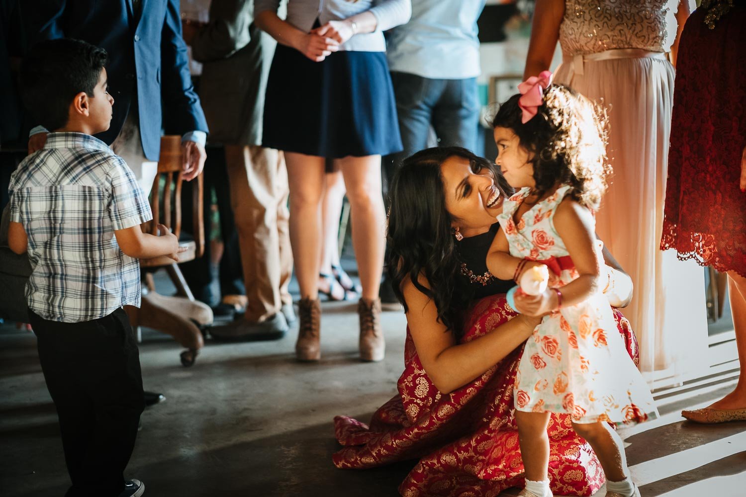 Bride cuddles young girl at The Infinite Monkey Theorem during a rehearsal dinner party
