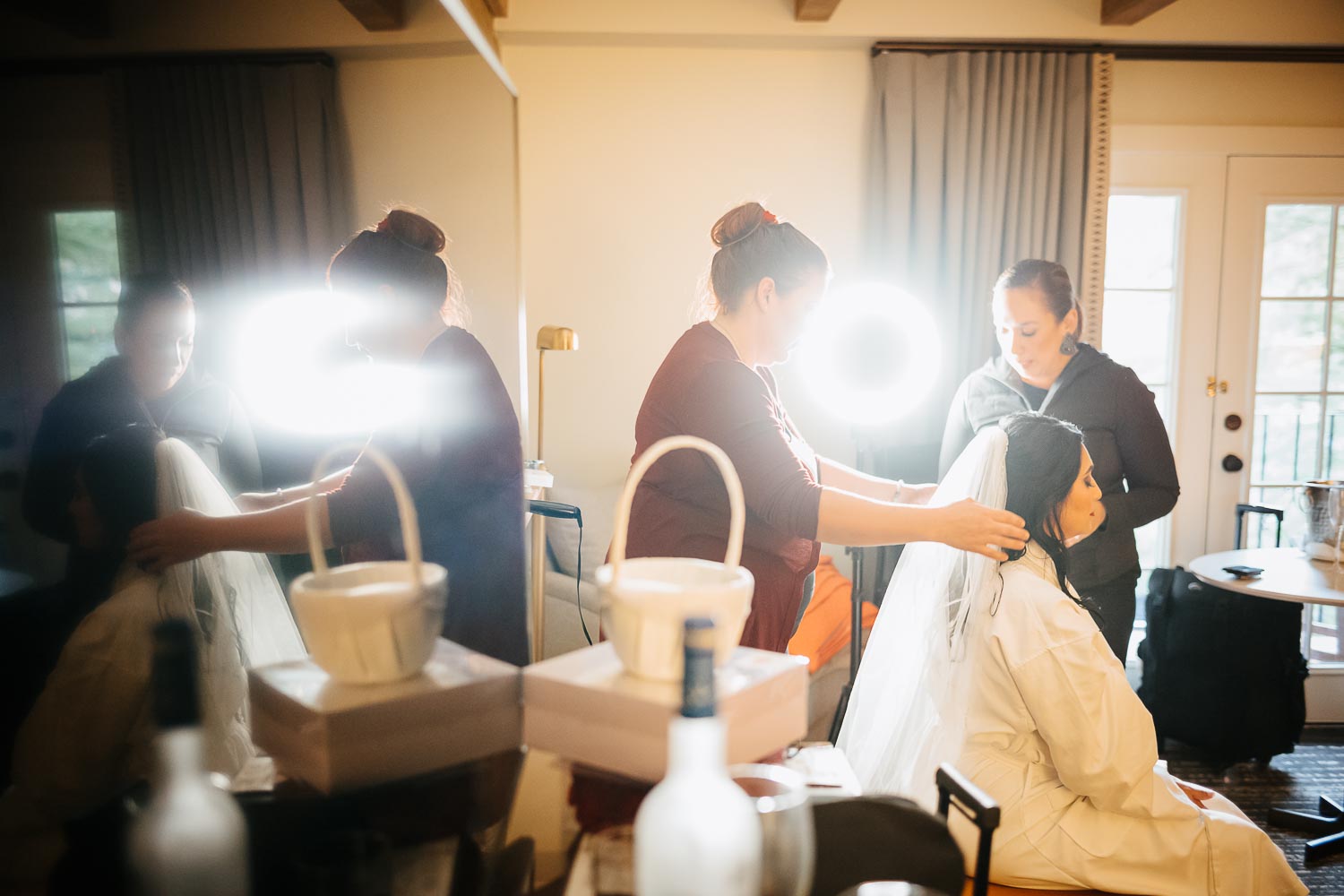 wide view in hotel room of bride in reflection mirror readying for her wedding day