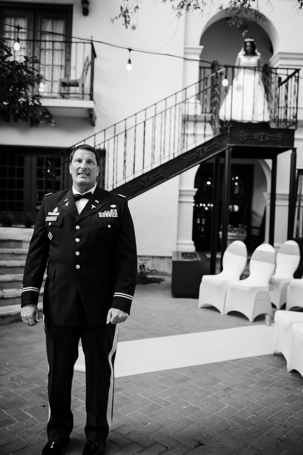 The first look between Walt, the groom, and the bride, Blanca descending down a courtyard staircase