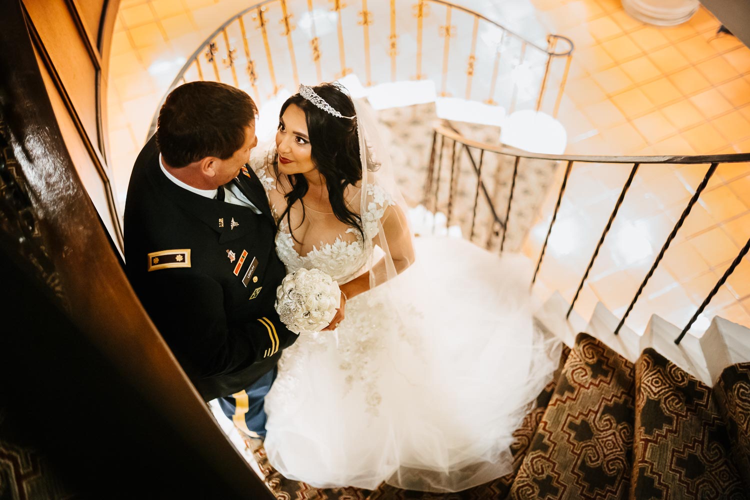 The couple on the famous staircase looking down following the spiral at Omni La Mansion Riverwalk hotel in San Antonio Texas