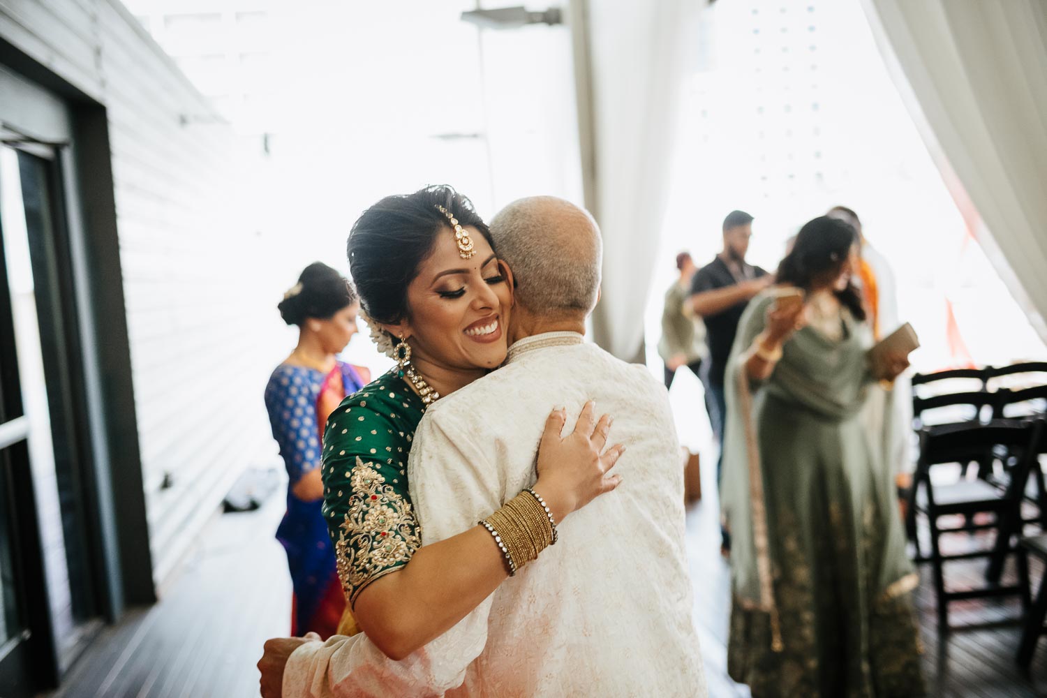 Father of the bride hugs and greets warm embrace at Brazos Hall Austin South Hindu asian wedding ceremony