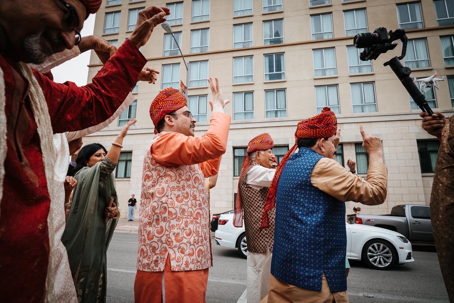 The baraat commences with lots of noise and family of the groom dance on the road Brazos Hall Austin South Hindu asian wedding ceremony