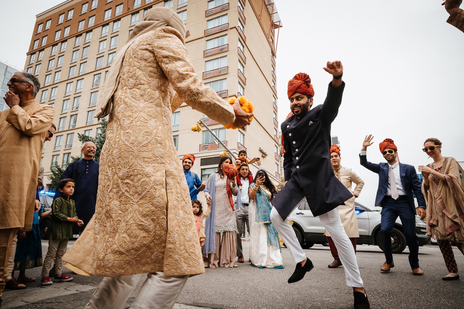 The Baraat with the groom and family friend dancing shot from a low angle