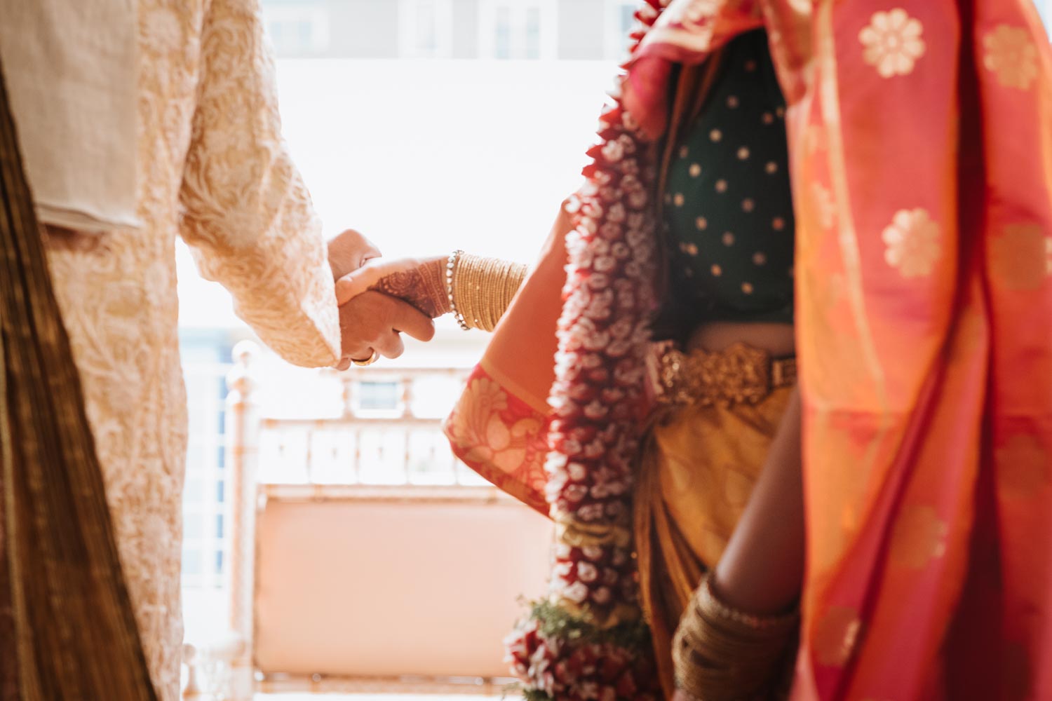 Bride and groom during south asian ceremony hold hands at Brazos Hall in Austin Texa