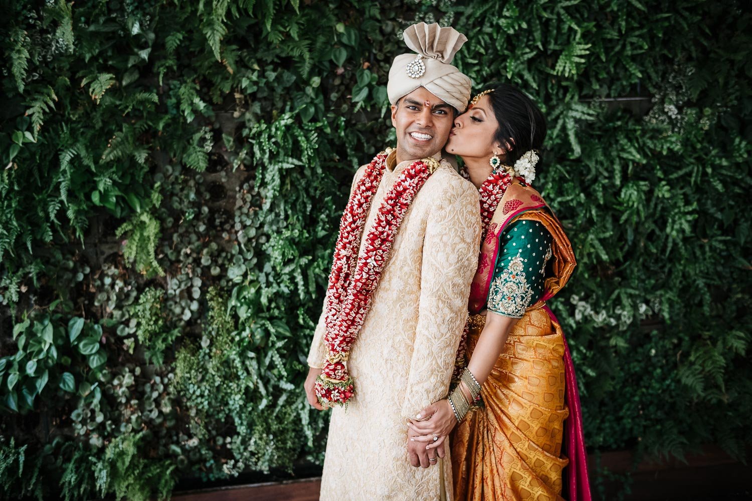 Brazos Hall couple marry - south asian Hindu wedding bride kisses groom on cheek
