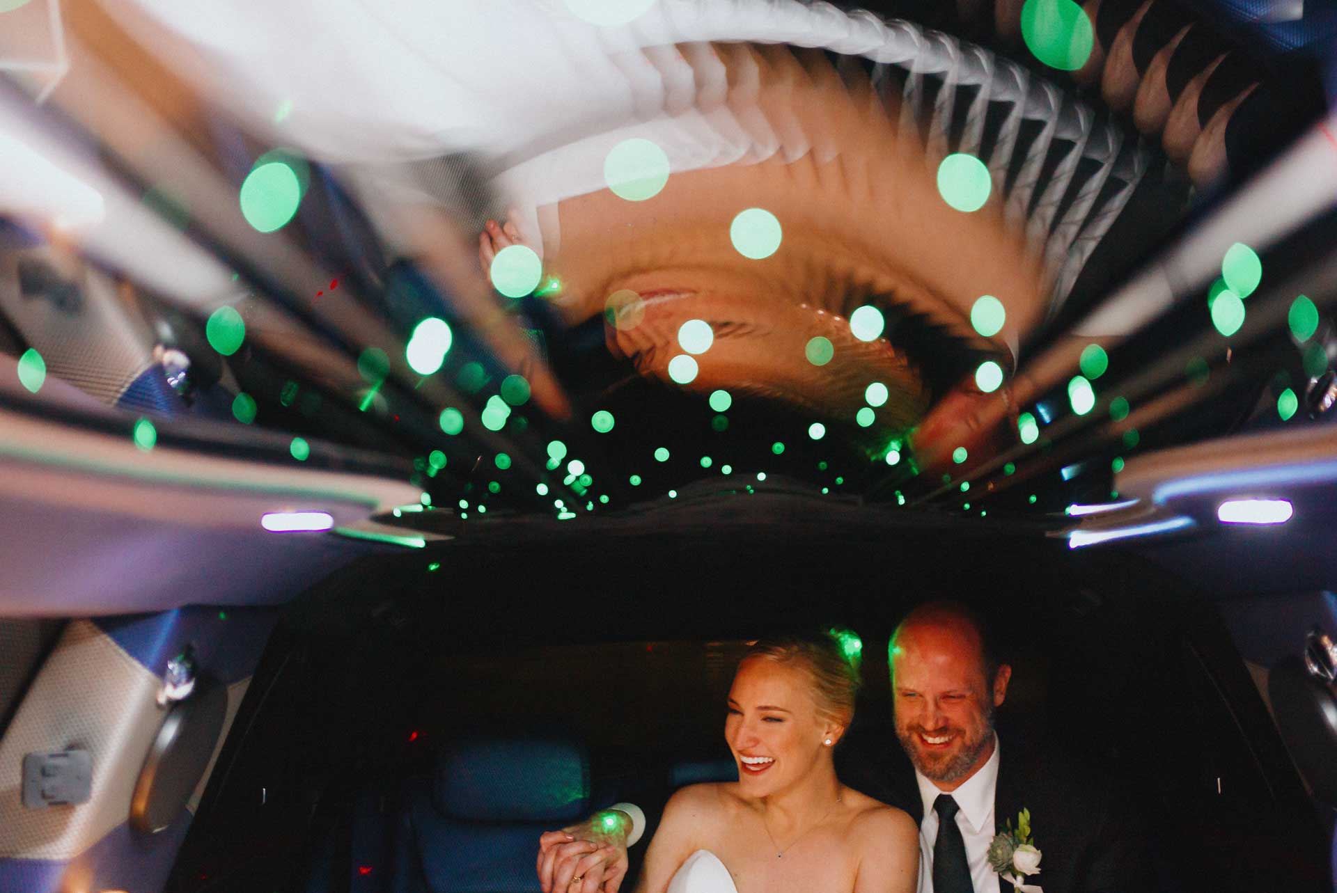 Couple Kelley and Erich share a funny moment inside a limo with green sparkling lights Houston Texas en route to Brennan's of Houston, Texas