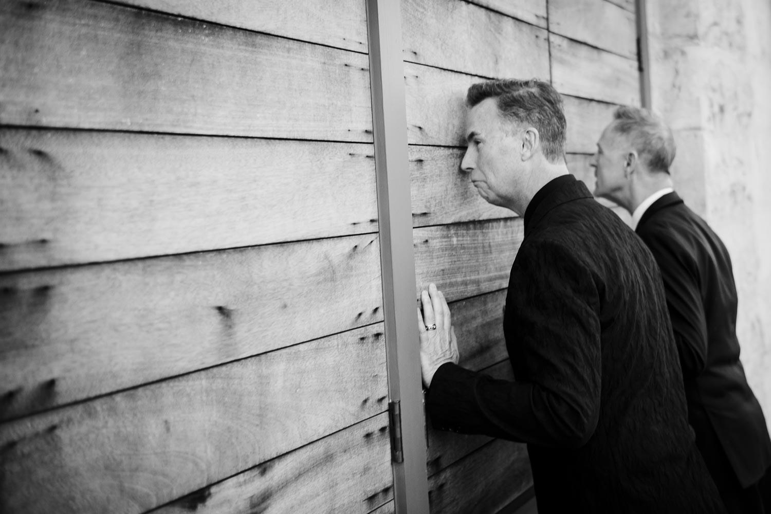 A favorite clicks of 2019 from my last wedding of the year. Here are two sweethearts, Densil and Stacy that tied the knot two weeks ago. The couple found holes in the fence of the venue and comically, were checking out guests heading toward their cocktail party after the ceremony. LM104330