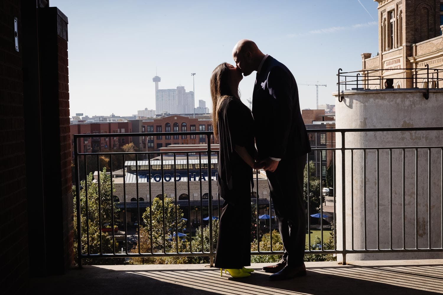 In a parking lot with view of downtown San Antonio skyline engagement shoot
