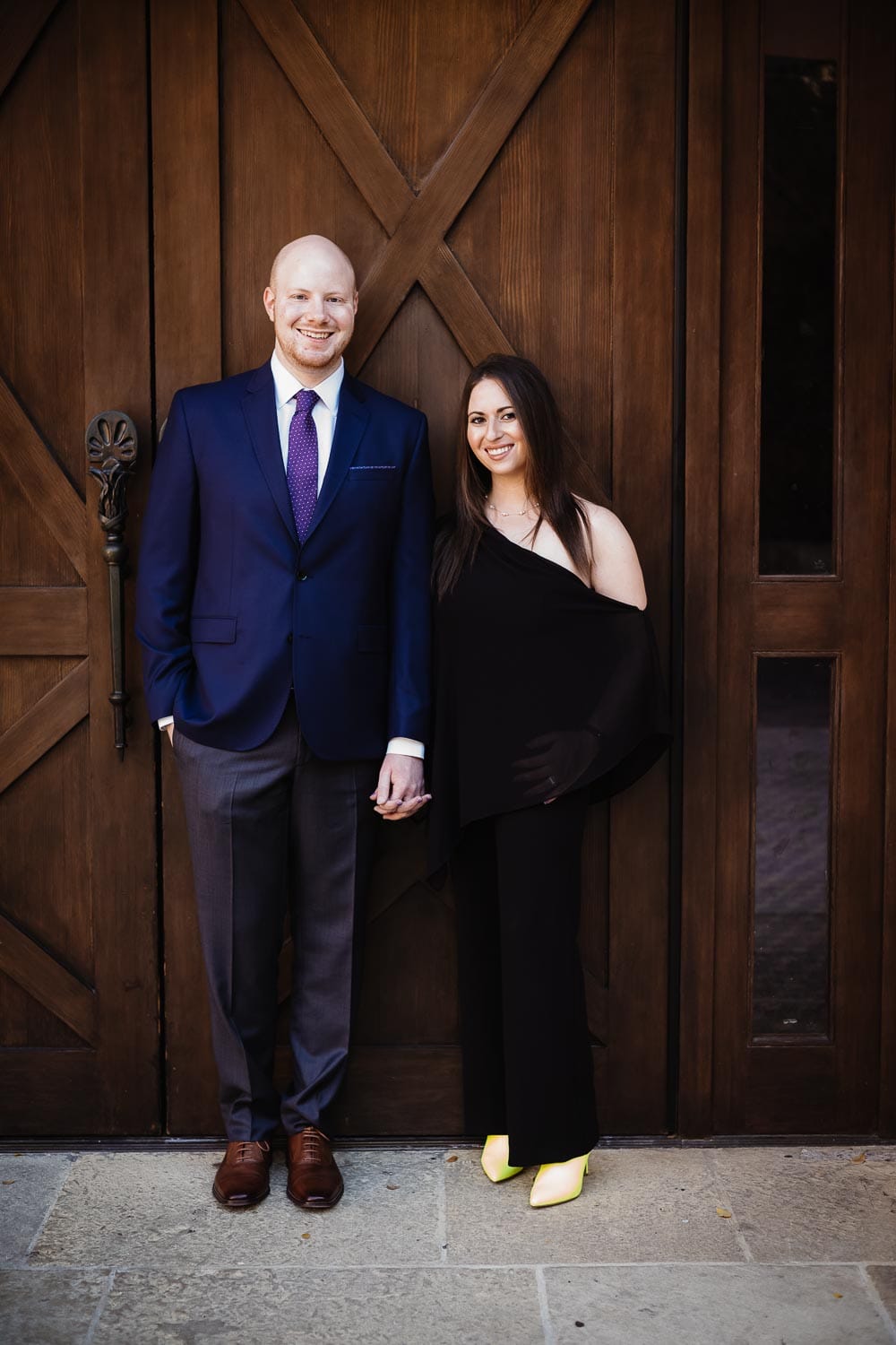 Engagement shoot couple Debra and Ryan standing against The Pearl Stables