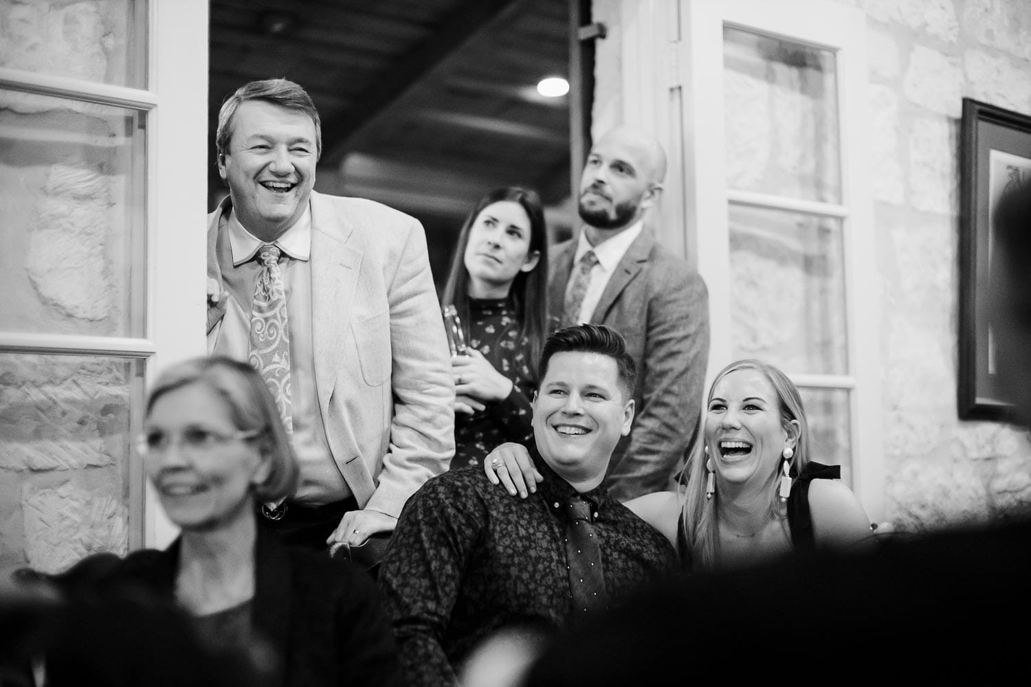 During the speeches at a welcome dinner shows coule Kelsey and Dan reacting in laughter