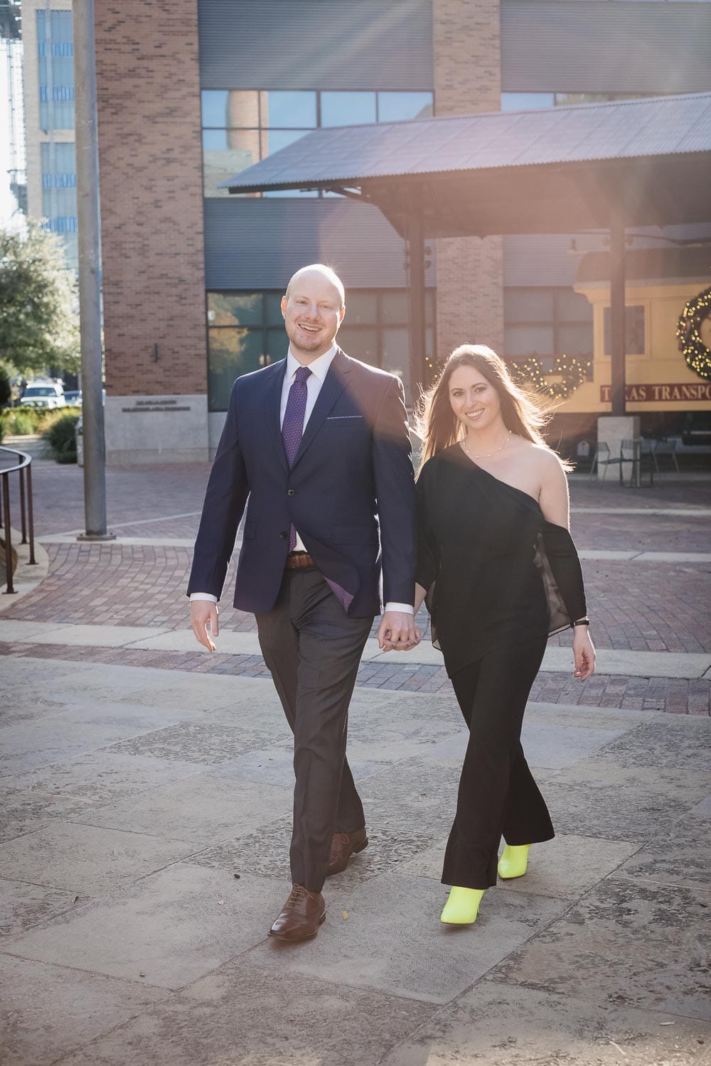 An old steam train sits idle in background as couple walk alongside Pearl Stables