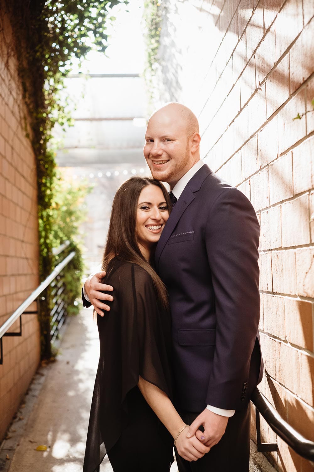 In an alleyway backlit early sunshine for couples engagement shoot at pearl brewery