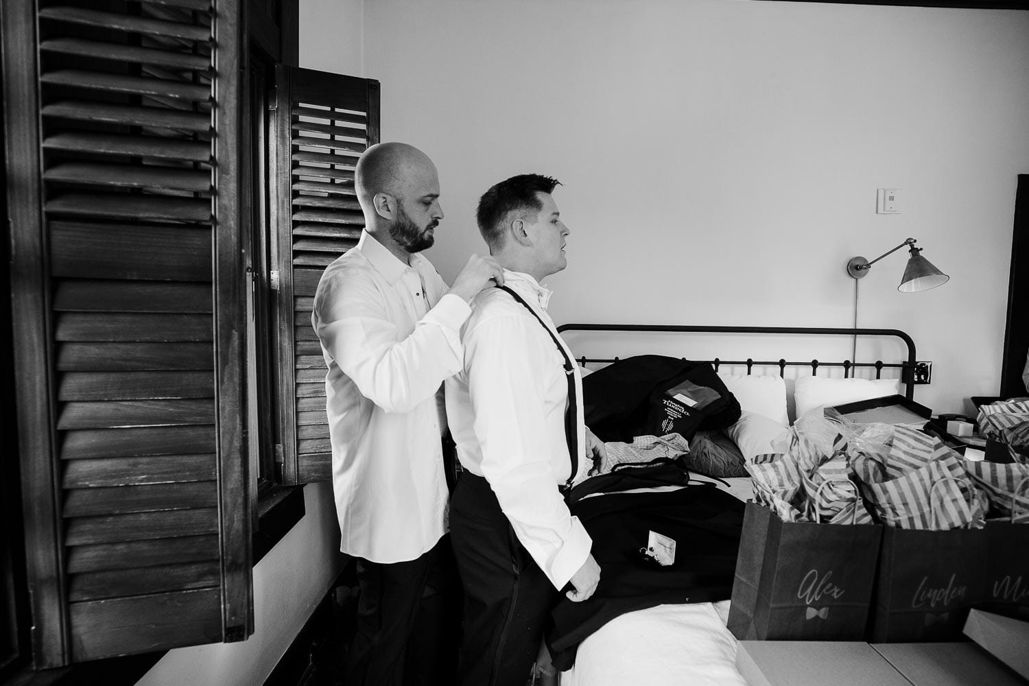The groom gets.a helping hand from a groomsman at Hotel Havana