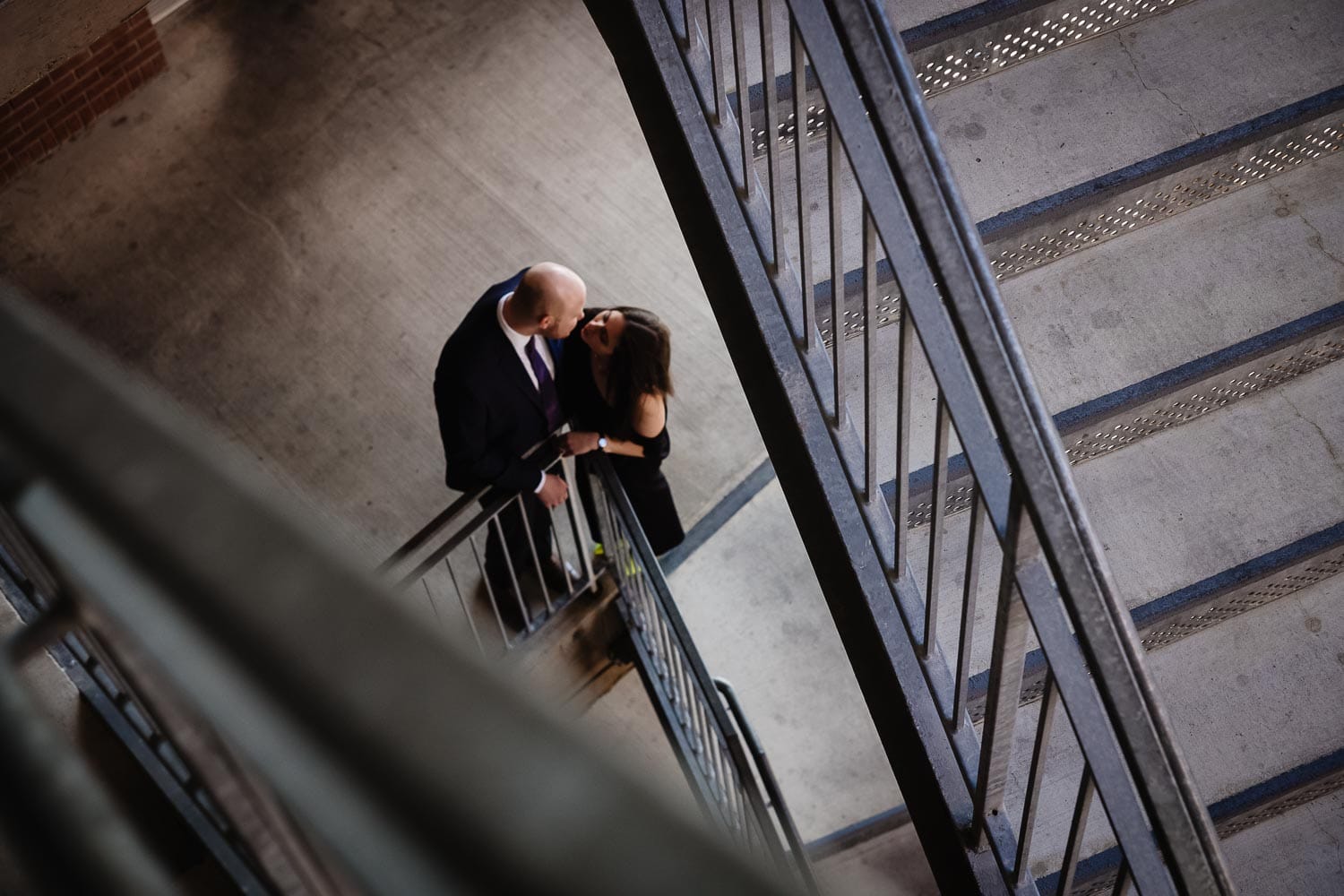 Looking down in-between staircase to couples engagement shoot