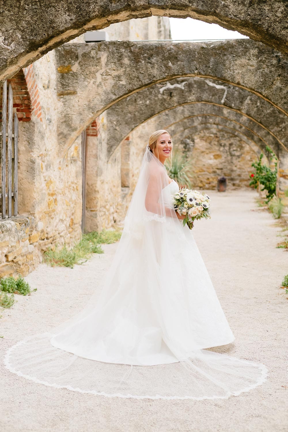 A bride poses for her bridal portrait at San Jose Missions San Antonio