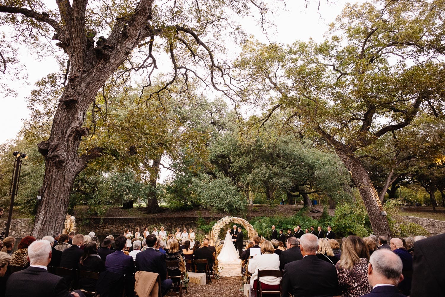 A wide shot of guests and the wedding ceremony outside at The Witte