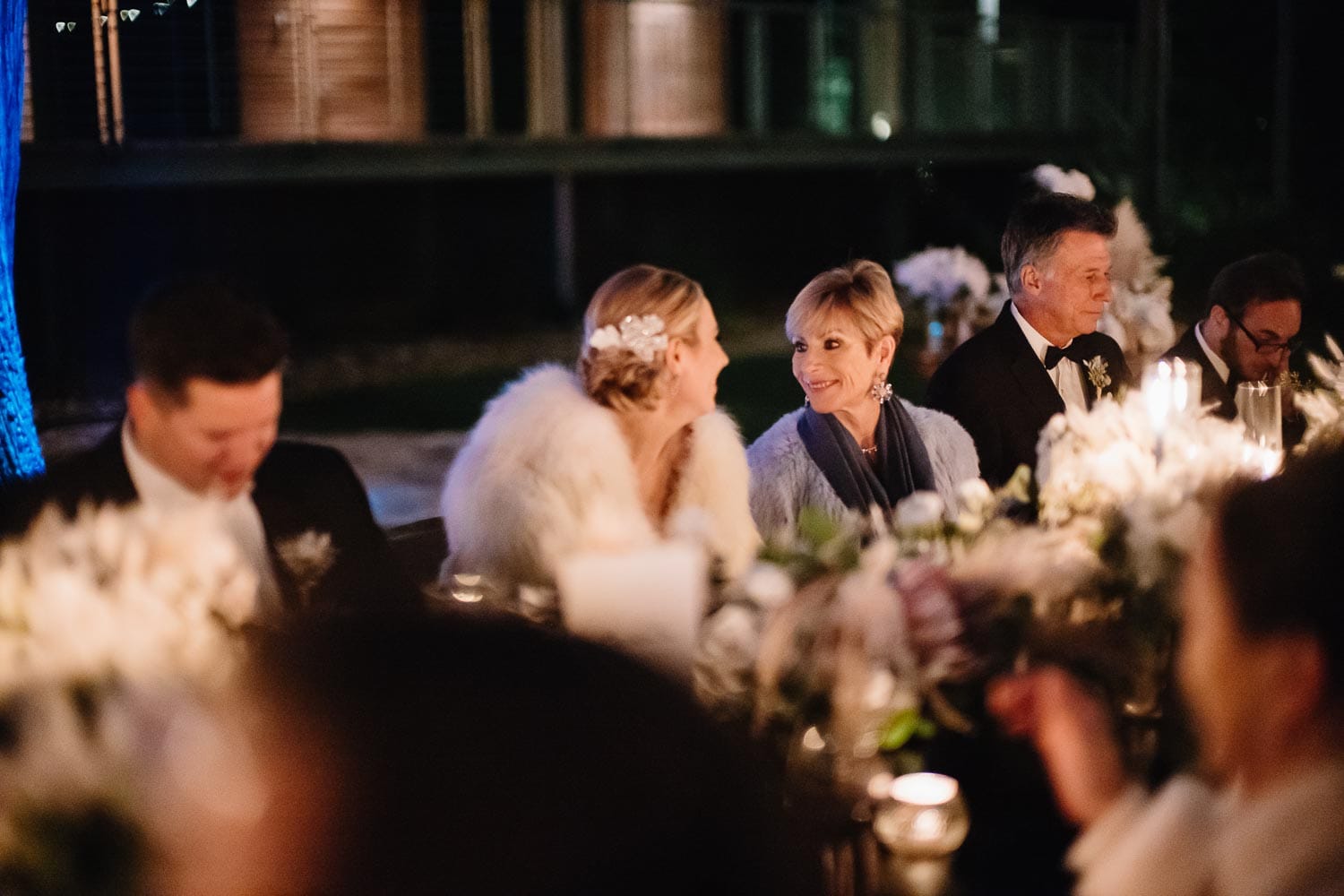 Mother and bride sit together at a wedding reception