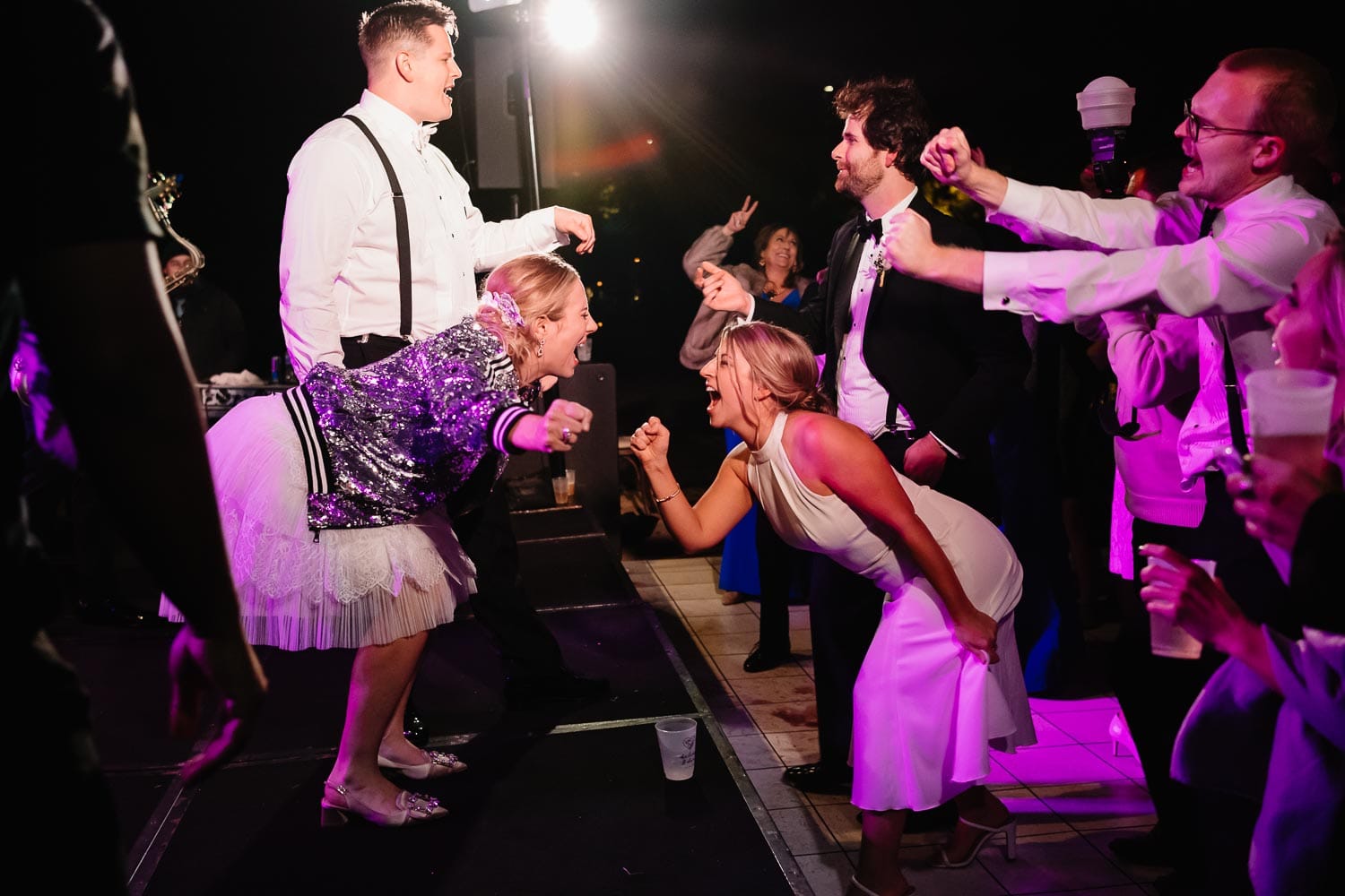 The bride and groom on stage with the in10city band at a fall witte museum wedding