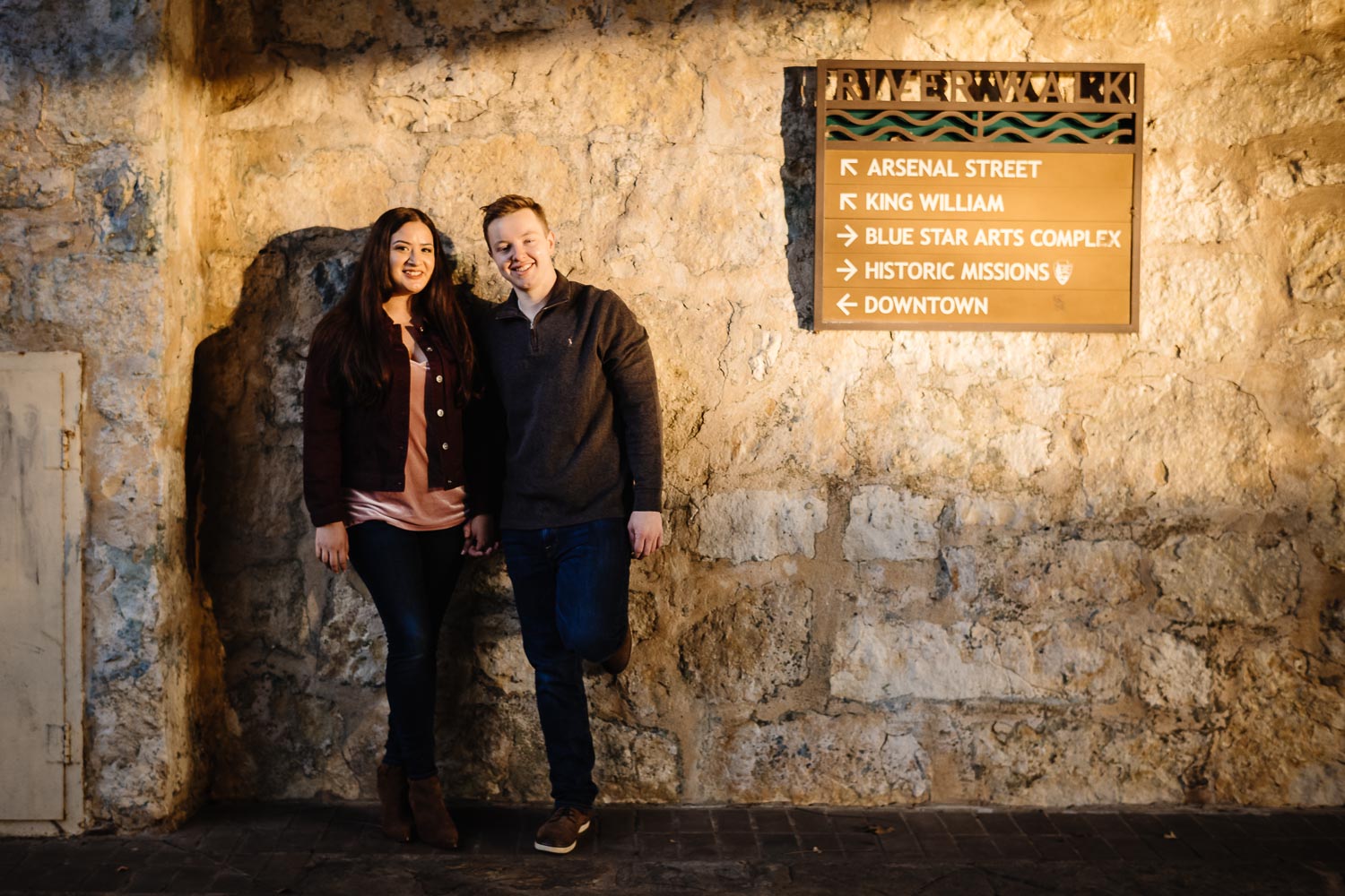 Couple under the bridge at sunset engaged