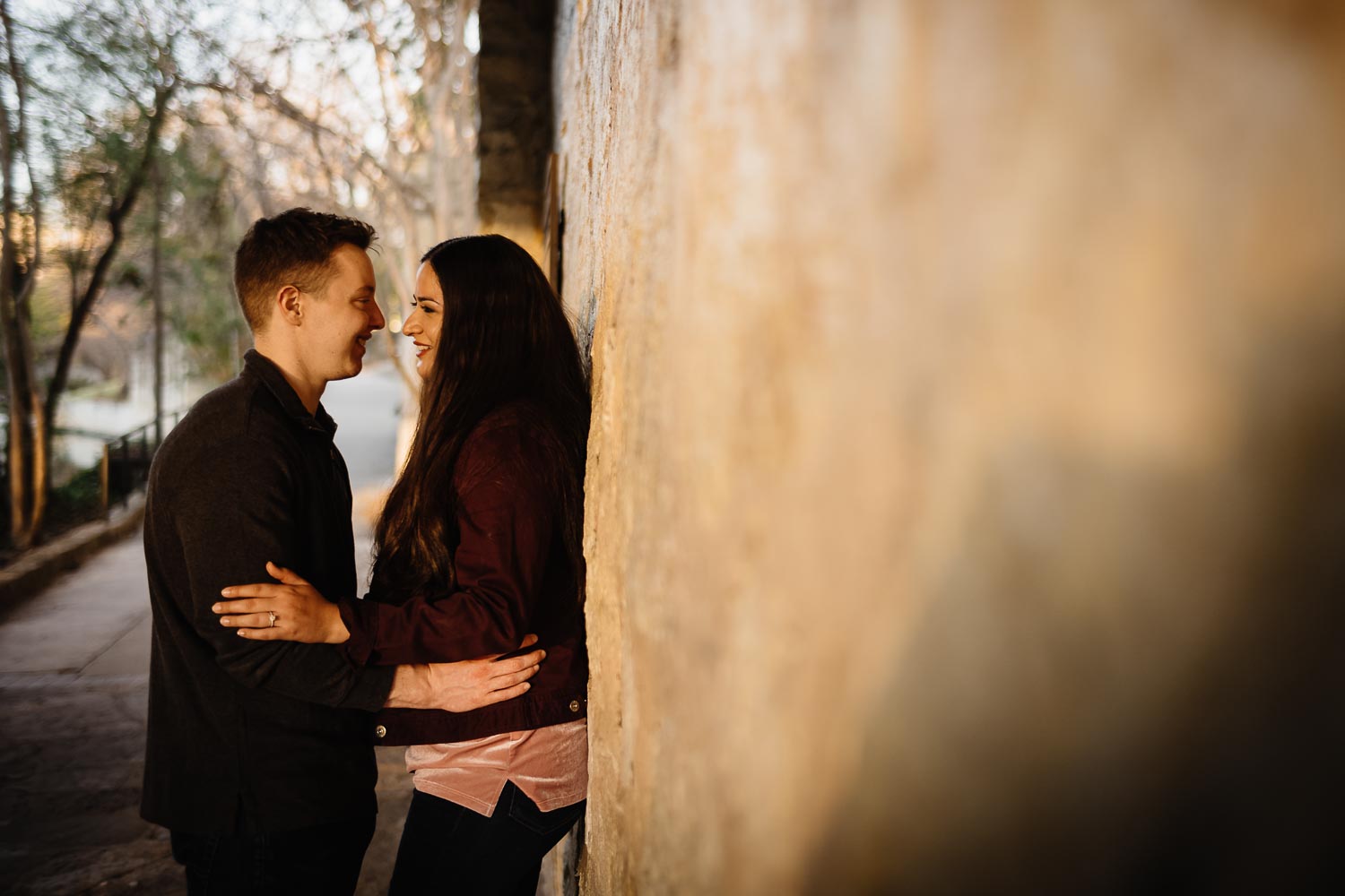 Engaged couple MIchael and Andrea snuggle closely