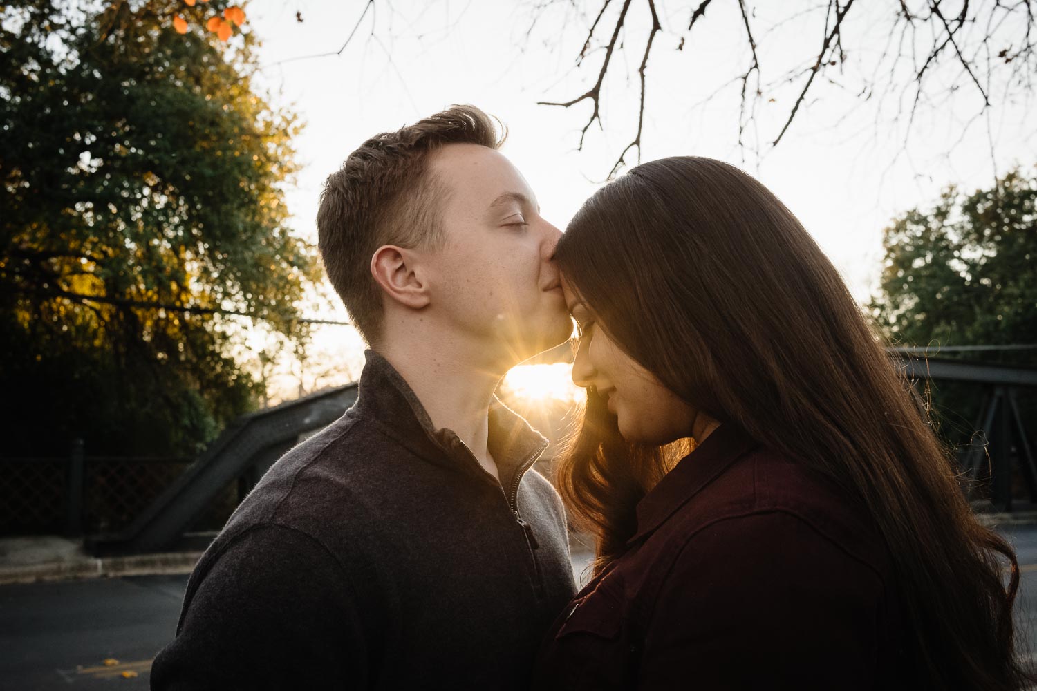 King William District Engagement  Couple kiss at sunset Arsenal Bridge over riverwalk