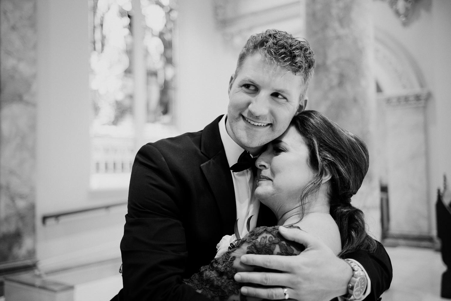 The groom hugs his teary eyed mother celebrating his marriage at the Incarnate Word Chapel San Antonio