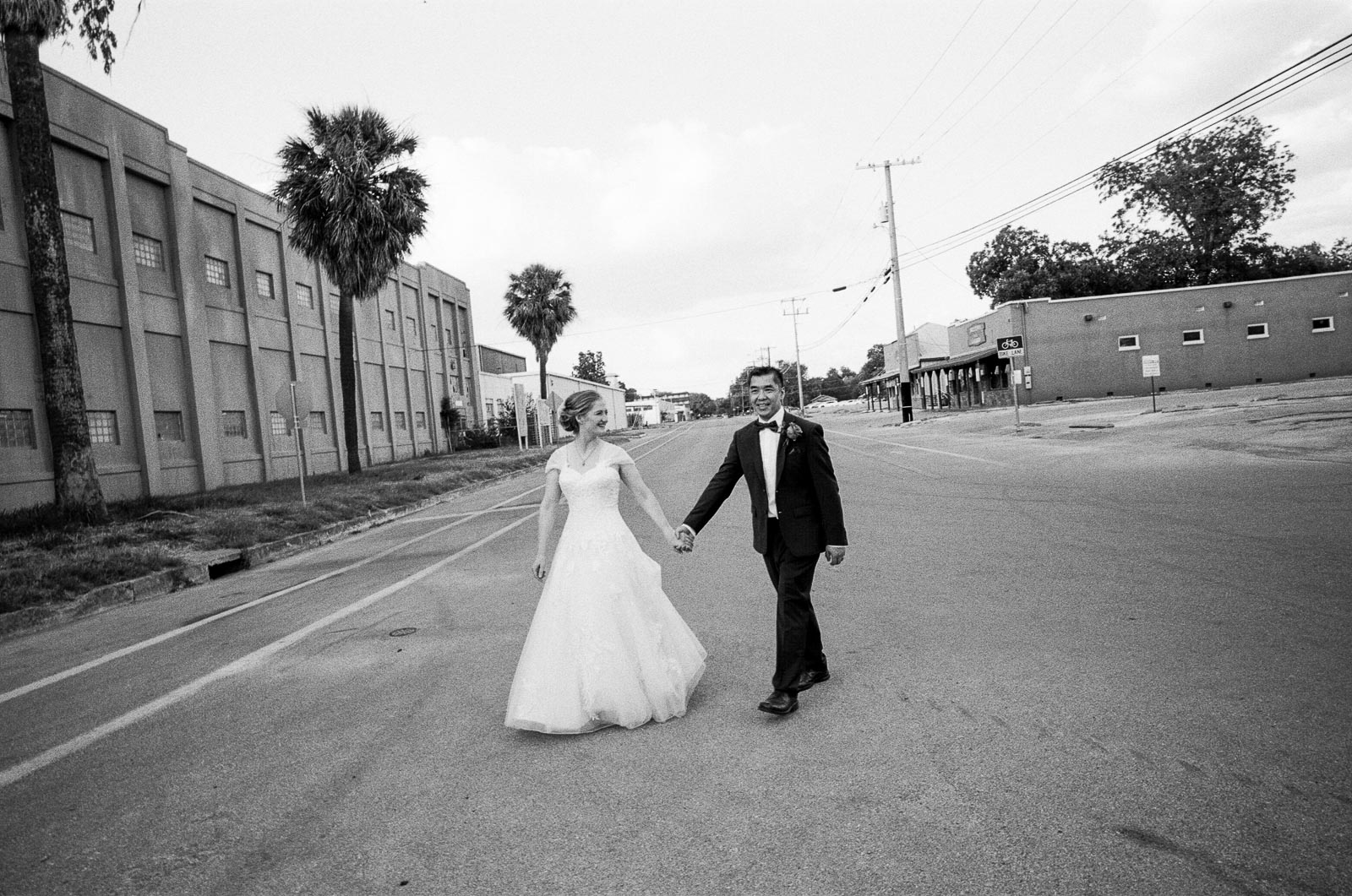 A wedded couple cross the street at Milltown Historic District in New Braunfels Texas