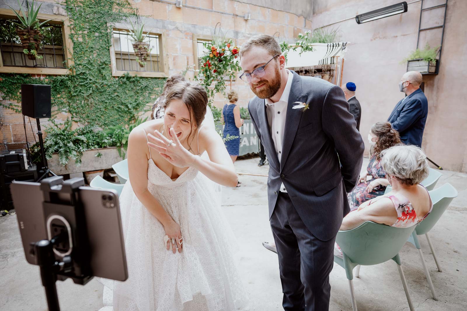 A couple receive congratulations via zoom during covid at a wedding reception in Houston Texas