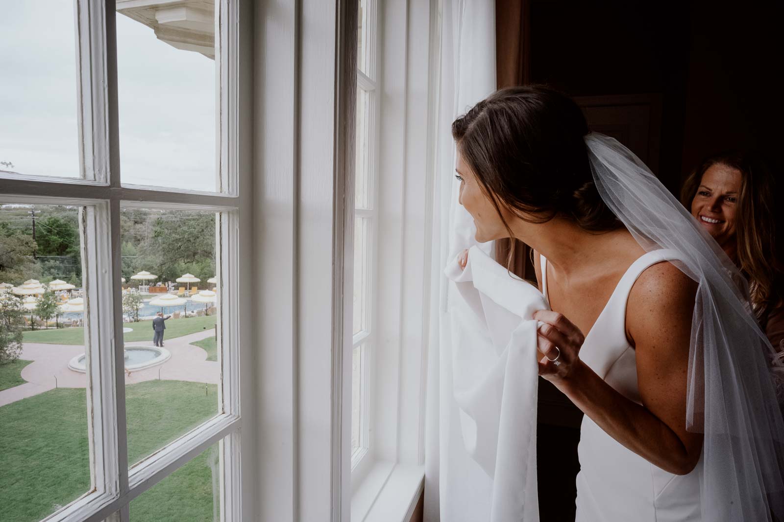 Bride looks out and sees the groom before wedding ceremony