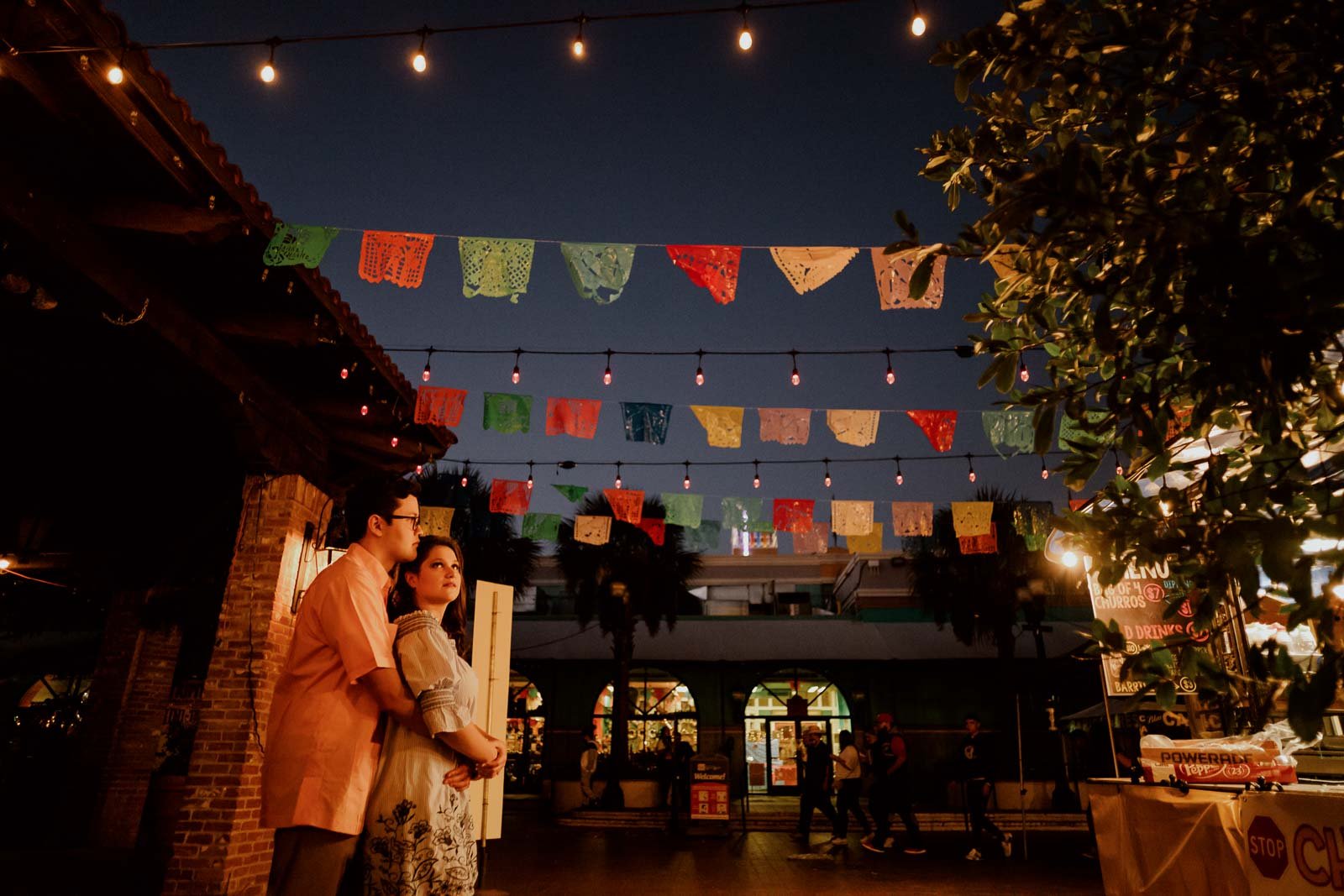 Historic Market Square engagement shoot showing colorful flags strung between buildings Leica Wedding Photographer-- 1San Antonio engagement shoot downtown - Philip Thomas