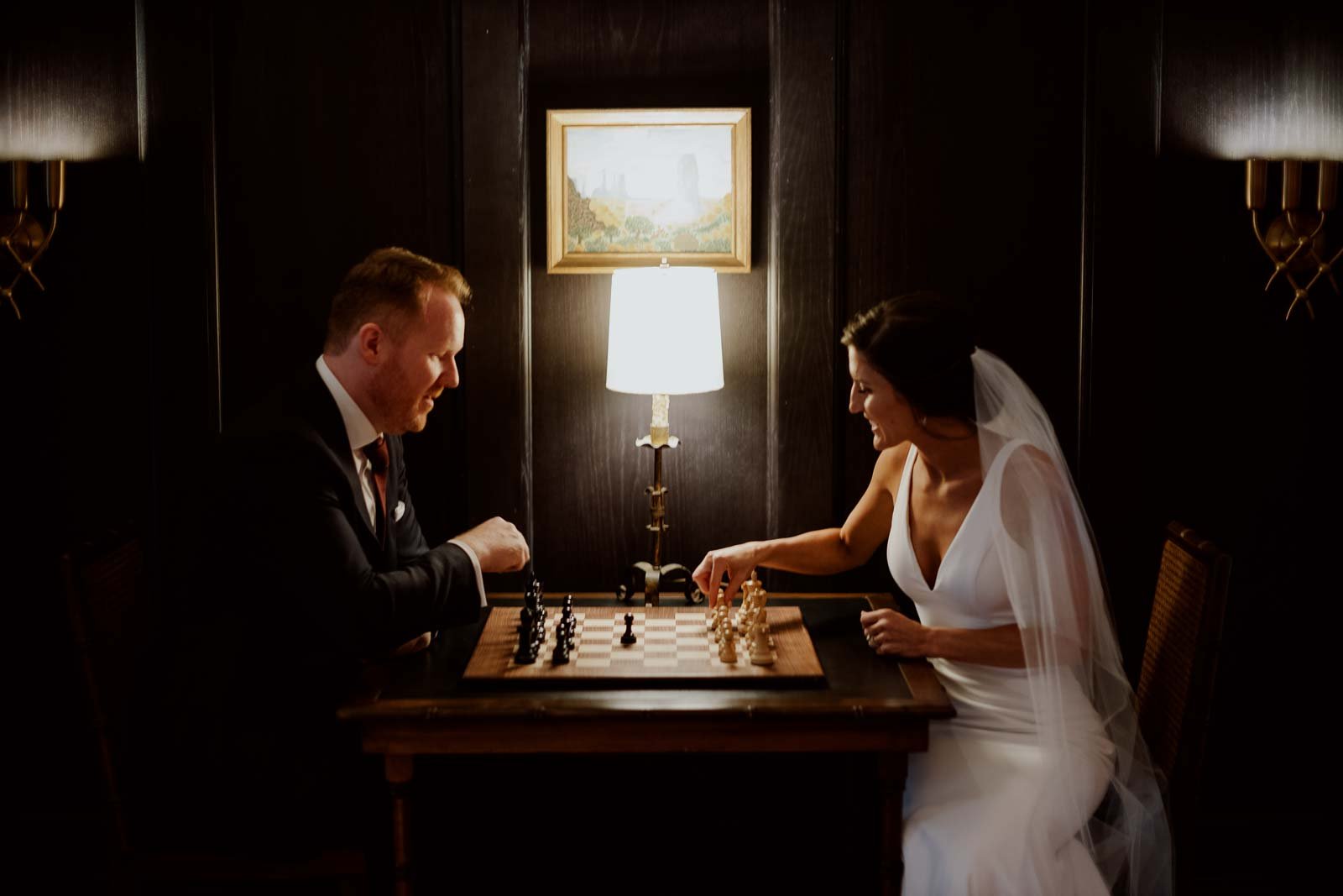 A couple play a round of chess during their wedding reception at Commodore Perry Estate, Auberge Resorts Collection, Austin, Texas.