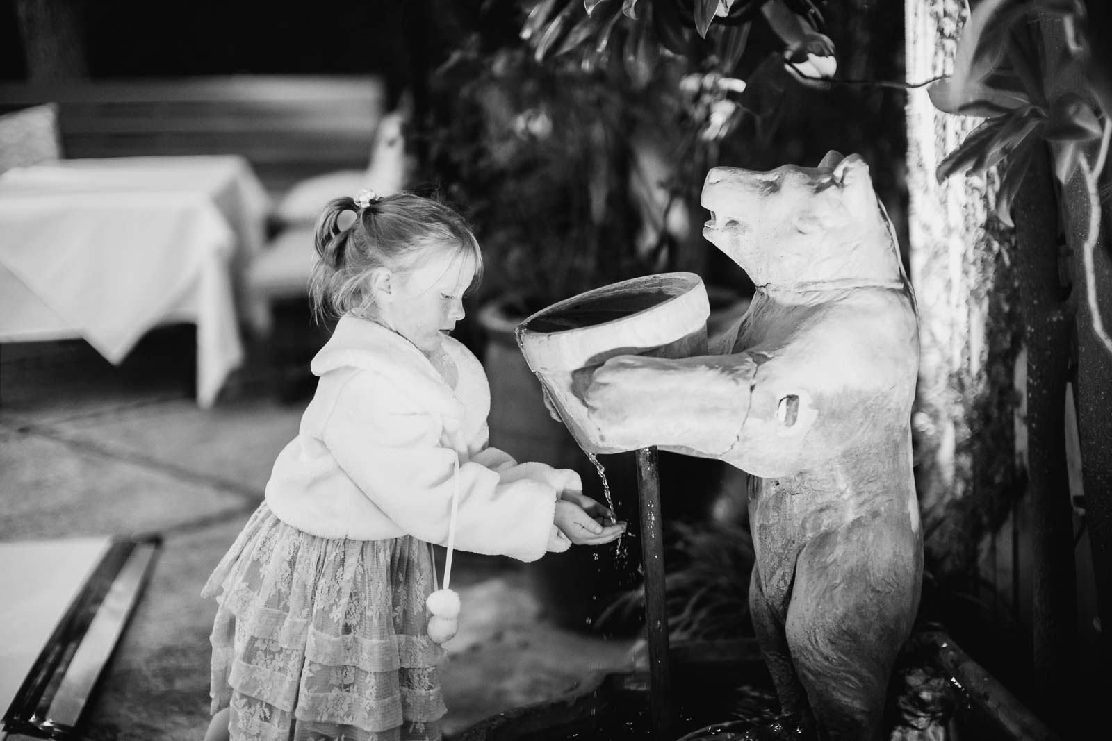  A little girl at a wedding reception Ouisie's Table in Houston plays with a water fountain