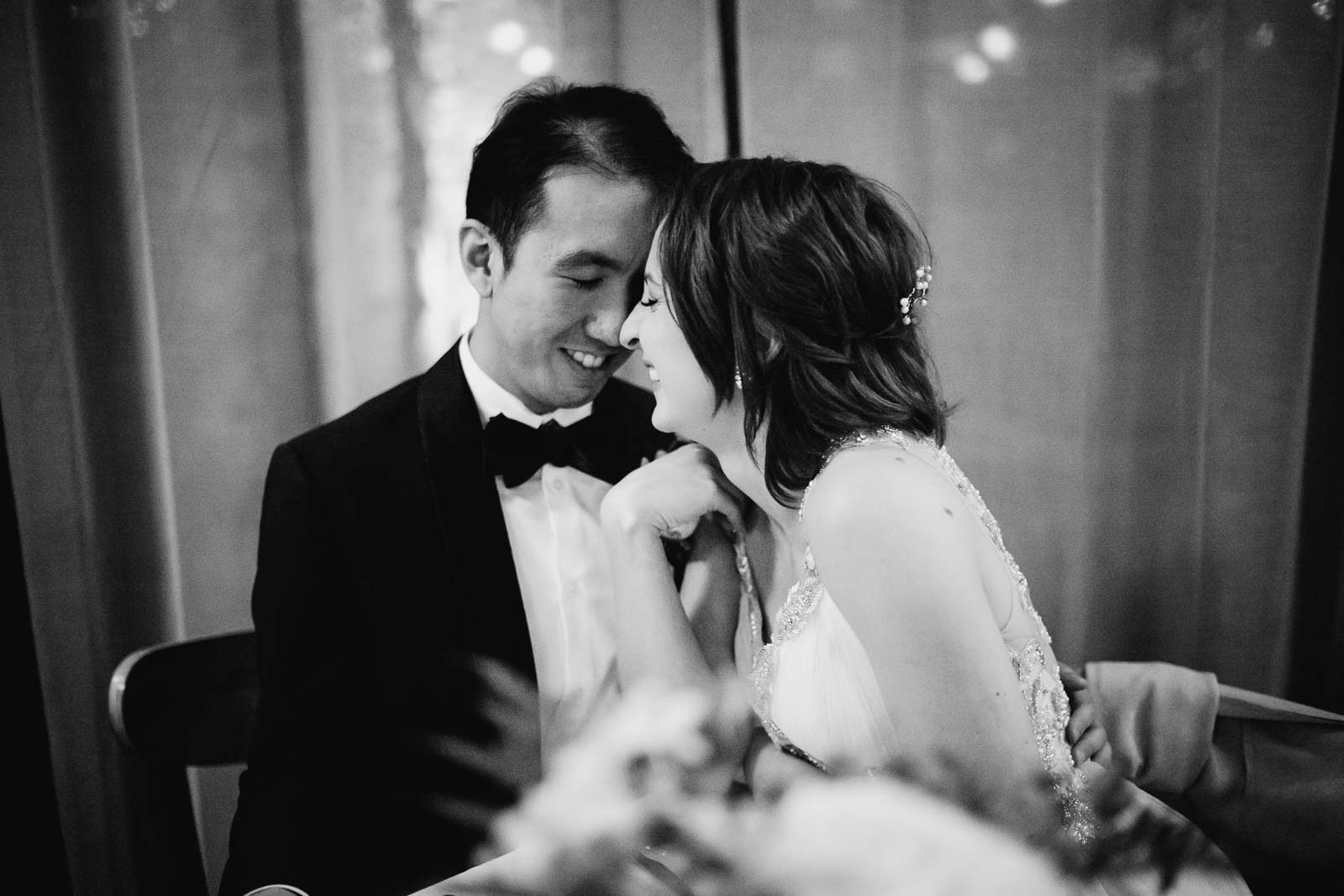 A couple sitting at their table share a beautiful moment at Ouisie's Table in Houston during their wedding reception