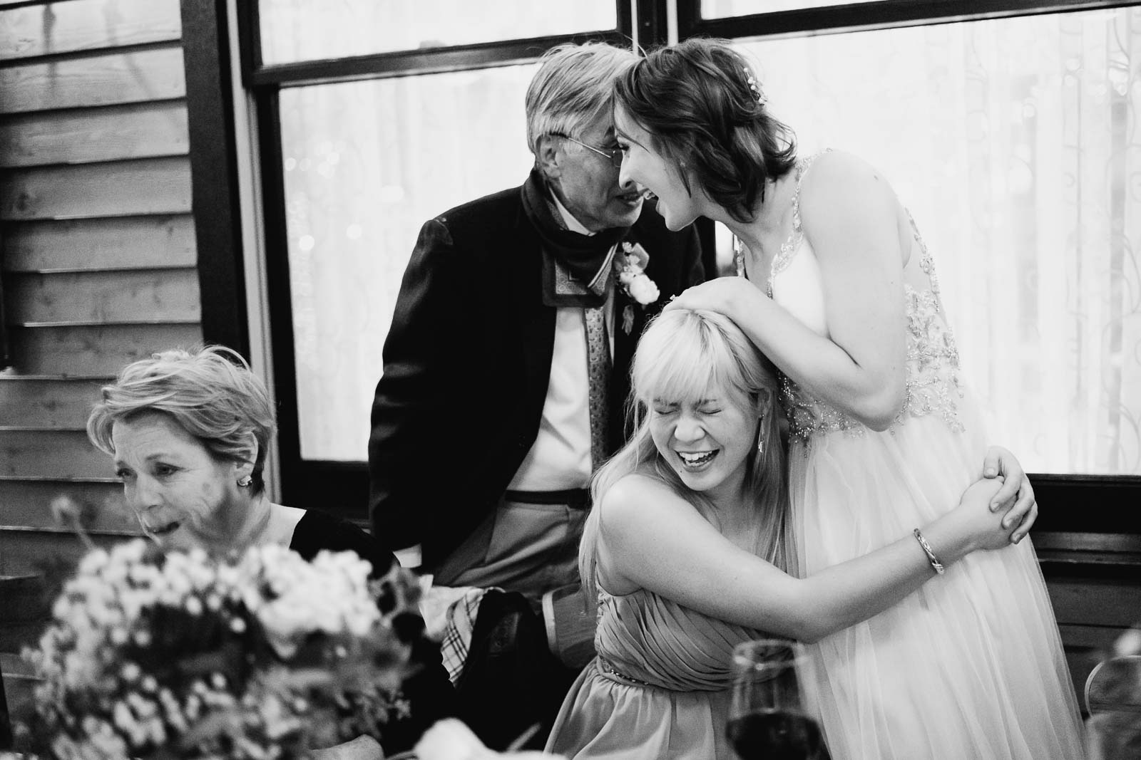 the bride and bridesmaids laugh with a guest at Ouisie's Table in Houston